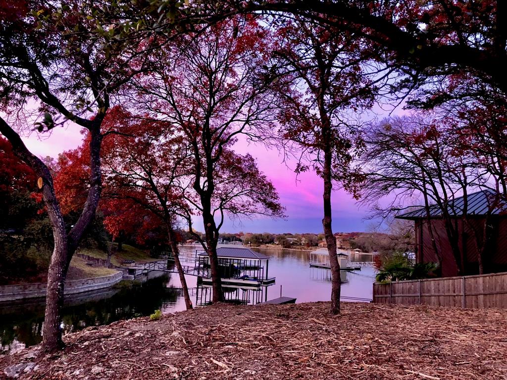 What has a nationally known architect as its creator, a pioneer of aviation as its owner, 5 minutes by boat to the famous Fort Worth Boat Club, over 2 acres waterfront (average on lake is .7 acres), 170' (average on lake is 100) frontage on the deepest slough on Eagle Mountain Lake and the closest location and street on EML to the Fort Worth lifestyle?? This property answers all those questions!
The interior is a clean slate to create a new masterpiece as the owners gutted a few years back and decided not to recreate but to sell to the next artist to put it back in its Glory Days. The song verse 'the sun poured in like butterscotch and stuck to all your senses' is a feeling that the owners and architect designed. What this 5,000 sqft, 4 bedrooms (more can be added), 4 bath, rolling 2.1 acres will be is only up to the new Buyer's creativity!. EML's premiere builder has spent time at the home and is excited to share his ideas. Imagine a walkout with pool, tennis, or pickleball courts, making this one of the most desirable homes on the whole of Eagle Mountain Lake. The street is tranquil, and hiking is recommended to experience a lake lifestyle. Take an 'As Is' and create a 'New Lake Front Estate IS'.
Some would call it 'As Sweet as Tupelo Honey'. Come Explore For Additional Benefits Hidden In Plain Sight.