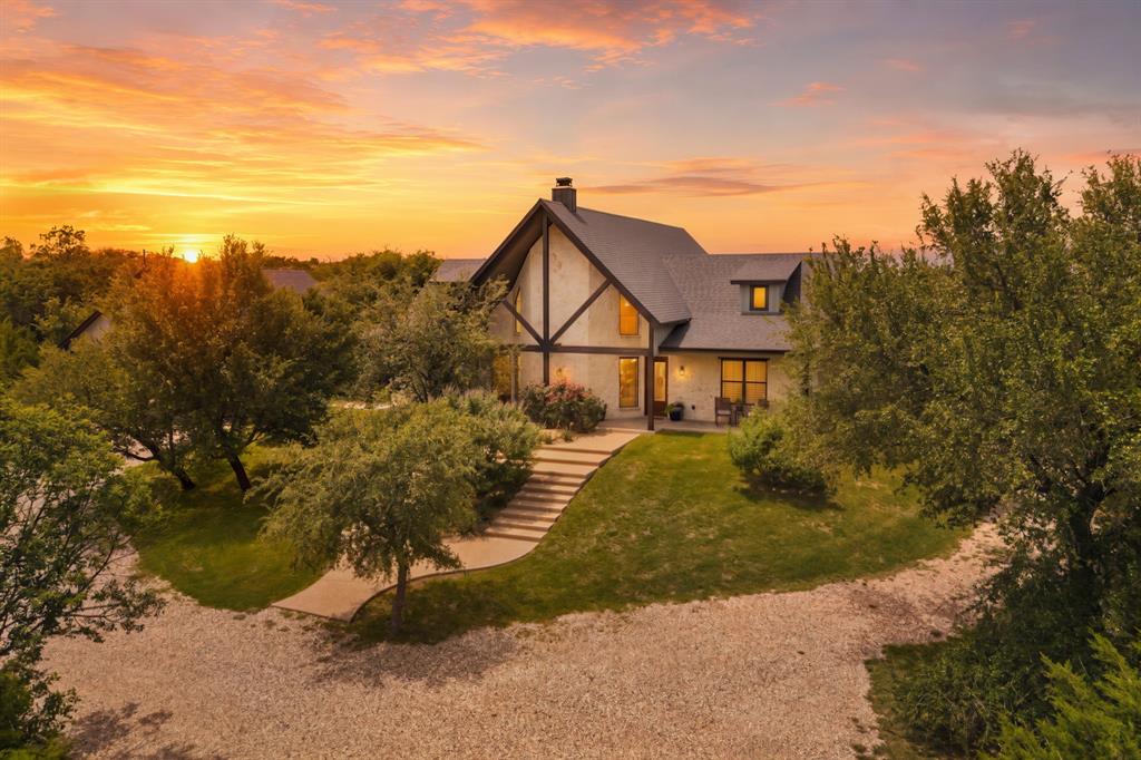 Tucked beneath a canopy of mature trees in a private, serene setting on 3.08 acres, this one-of-a-kind modern rustic home is a true showcase of craftsmanship and thoughtful design. Built by a master craftsman, every detail reflects quality—from the luxury vinyl wood look flooring to the eye-catching diagonal tongue-and-groove ceilings that bring character throughout. The impressive living area is anchored by a stunning 20-foot fireplace, designed for both wood-burning and gas logs, creating a dramatic and inviting focal point. A wet bar adds convenience, making the space perfect for entertaining or unwinding at the end of the day. The gourmet kitchen is designed to impress, featuring leathered granite countertops, a massive 20-foot island with ample amount of storage for all kitchen items, ideal for gathering and prep, custom cabinetry, a gas range, and a wine fridge. Pantry with built-in desk and space for stacked washer and dryer. Artistic faux-finished walls throughout the home add a unique and elevated touch. This four bedroom, four bathroom home features a privately situated primary suite that offers a coffered ceiling, patio access and peaceful views of the surrounding landscape. The luxurious ensuite bath includes dual vanities, a soaking tub, walk-in shower, bidet, and a spacious, well-appointed closet with built-ins. Laundry room with freezer space. Two guest bedrooms with their own private baths. The 4th bedroom could be a second primary with a full bath, sitting area, kitchenette and a separate outdoor entrance, private deck, and sweeping sunset views.  Step outside to your own private retreat, complete with a covered patio with a relaxing dry sauna, overlooking a sparkling, in-ground gunite pool with a tranquil waterfall.  Adding even more flexibility, the garage includes a guest suite with two bedrooms, a full bath, and a kitchenette—perfect for extended family or multi-generational living. You must see the quality in this unique property. $999,900