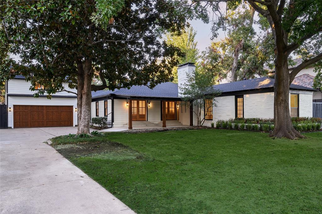 Fully reimagined and exquisitely finished, 6021 Northwood Road is a Preston Hollow jewel on a rare .405 acre homesite in the golden corridor. Mature trees and classic curb appeal frame painted brick and siding, stained wood garage doors, and twin French doors that open to a broad front porch. Inside, sunlight fills a connected plan designed for everyday living and entertaining. The chef kitchen shines with a waterfall quartz island, natural wood cabinetry, white shaker uppers, floating shelves, pendant lighting, and a brand new THOR appliance package with pro style range, vented hood, French door refrigerator, and integrated dishwasher, plus a pot filler and deep sink. Beautiful smaller plank herringbone floors and recessed lighting run through inviting living areas, including a cozy sitting room with fireplace and an expansive family room with custom built ins. Walls of windows and more French doors bring in leafy views throughout the day. The main level hosts three bedrooms and three and a half refreshed baths, highlighted by a serene primary suite with picture windows and room to lounge. A private fourth bedroom and fourth full bath sit above the garage, ideal for guests, office, or an au pair. Outside, the estate size lot delivers broad lawns beneath a mature canopy, an extended driveway for generous parking, and room to add a pool or future outdoor living. Set mid block on a prestigious, tree lined street, the home is minutes from top private schools, Preston Royal Village, NorthPark, and favorite Dallas dining. Move in ready and truly special, it pairs classic Dallas character with fresh modern luxury.