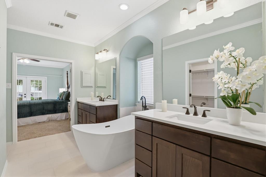 Discover this exceptionally updated two-story home nestled on a lake-facing lot in the master-planned community of Providence Village. A beautifully landscaped exterior invites you inside with sweeping wood-look tile floors and awe-inspiring 19-ft. ceilings. Situated off the foyer is a versatile flex room that could serve as a home office, formal dining room, or playroom. Make your way into the open-concept living space designed with both style and functionality in mind. The living room features a cozy electric fireplace with a modern tile surround, built-in media cabinet, and soaring ceilings. Fall in love with the chef-inspired kitchen equipped with Quartz counter-tops, custom cabinetry with exceptional storage, a two-toned island, sleek stainless steel appliances, dual ovens, and decorative tile backsplash. The breakfast room offers a large built-in banquette with additional storage. Thoughtfully located on the first floor, the primary suite features French doors overlooking the backyard oasis. The beautifully updated ensuite bath showcases dual Quartz-topped vanities, a freestanding soaking tub, updated tile shower, and spacious walk-in closet. Head upstairs to the expansive game room with a built-in storage bench and plenty of space for a pool table. You'll also find a peaceful balcony, three additional bedrooms with closet systems, and a full bath. Enjoy slow mornings relaxing on the charming front porch listening to the tranquil lake fountain, or unwind after a long day in your private backyard complete with an extended patio and serene Koi pond. Additional updates include a new AC unit and water heater (2022), garage door insulation, and added attic insulation for enhanced energy efficiency. Residents enjoy incredible amenities within walking distance including the catch-and-release pond, swimming pool, basketball courts, skate park, playgrounds, and more, plus Monaco Elementary School just moments away.