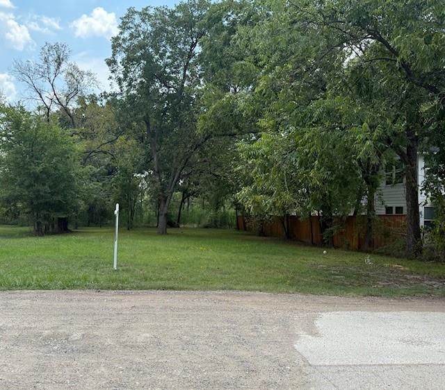 Beautiful trees on this 50x135 residential lot with newer homes being built in the area, this corner lot is ready for its home too! Lots of trees including large, mature pecan trees add privacy and beauty with welcoming shade for the yard. Active water meter used for watering grass and city sewer line on property. You'll find plenty of street parking for gathering friends or family while also being close to the downtown area and to Texas A&M-Commerce. The lot size fits those looking for lower yard maintenance. Could be a personal home or build to rent!
