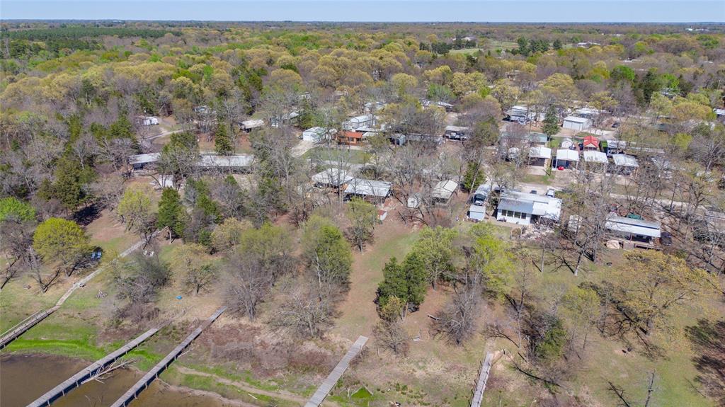 WATERFRONT PROPERTY ON LAKE FORK! Are you looking for a serene getaway at Lake Fork? This is a truly unique and rare find! Located on 10 wooded lots in the exclusive gated community of White Oak Shores.  You have to come and experience the privacy and peaceful location.  There are multiple residences for you and your family and guests to enjoy.  There primary residence is a 2009 Park Model that’s approximately 400 feet and can sleep 4.  The secondary residence is a 2006 Gulfstream Cavalier that sleeps 6.  It has a primary bedroom as well as the bunks in back. Both have steel covers. The Park Model has a 600+ square foot Hurricane deck with pressure treated lumber, double roof support structure and steel purlins for ultimate quality and protection of the structure. Other highlights include a 90 foot boat dock with 10x12 patforms on middle and end, chip sealed driveway in excellent condition and 20 amp electrical on the entire property. There’s a 4x6 in ground cinder block barbecue (big enough for a whole pig) and walking trails on the acreage.  Can’t forget the little single sleeper that would make an adorable she shed or child’s fun camper! White Oak Shores features community pool, playground  and club house. Best of all…private community dock and boat ramp! Hurry out to experience this getaway, as pictures cannot do it the justice it deserves.