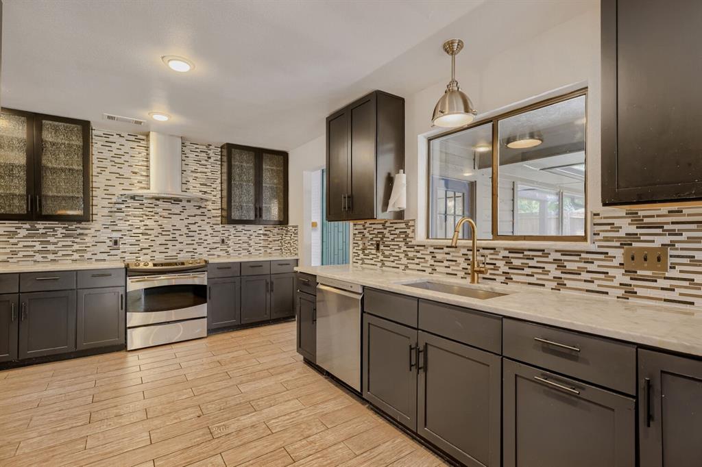 Designed for both comfortable living and entertaining, this spacious home offers multiple gathering areas and thoughtful details throughout. Upon entry, you're welcomed by an inviting layout that opens into two generous living spaces connected by a striking double-sided fireplace, creating warmth and character from room to room. The kitchen features a casual dining area perfect for everyday meals and morning coffee, while decorative lighting throughout the home adds style and ambiance. The primary suite provides a relaxing retreat with a well-appointed bathroom featuring a separate soaking tub and shower. Step outside and discover an exceptional outdoor living space designed for entertaining, complete with a built-in grill and outdoor kitchen area. Views from the den overlook this backyard retreat, creating a seamless connection between indoor comfort and outdoor enjoyment.