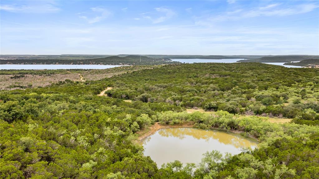STRINGER RANCH 1,104 ACRES  PALO PINTO COUNTY, TEXAS

Stringer Ranch is a rare 1,104 acre ranch in Palo Pinto County offering exceptional scenery, diverse terrain, and sweeping views of Possum Kingdom Lake. Held by the same family for generations, this large contiguous tract presents an outstanding opportunity for recreational, agricultural, investment, or residential use.

Conveniently located west of the DFW Metroplex, the ranch provides privacy and seclusion while remaining easily accessible. Dramatic elevation changes, rolling ridges, deep draws, and scenic valleys create a landscape rich in character and natural beauty. Numerous elevated locations offer spectacular views of Possum Kingdom Lake and the surrounding countryside, providing multiple potential homesites.

The ranch is heavily wooded with a mix of native hardwoods, mesquite, cedar, and dense brush, creating excellent wildlife habitat. Whitetail deer, turkey, wild hogs, and other native species are commonly found throughout the property, making it well suited for hunting and wildlife management.

Its size and varied topography support a wide range of uses, including cattle grazing, recreational activities, equestrian pursuits, trail riding, hunting, conservation programs, and the development of a private ranch headquarters or family retreat. The extensive acreage and diverse landscape provide flexibility for future improvements and long-term ownership objectives.

Large ranches of this scale with significant elevation changes, scenic views, and proximity to the DFW area are increasingly difficult to find. Stringer Ranch offers a unique combination of natural beauty, privacy, recreational appeal, and versatility in one of North Texas' most desirable ranching regions.

Whether you are seeking a recreational getaway, working ranch, investment property, or a place to build your dream ranch estate, Stringer Ranch presents an exceptional opportunity to own a premier North Texas property.