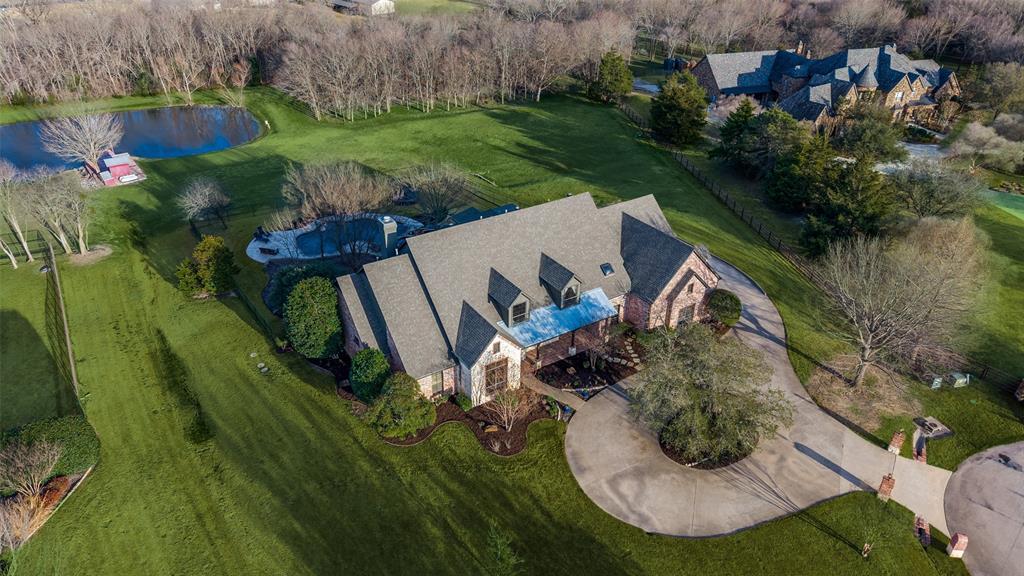 Welcome to one of Prosper's most extraordinary estates. A rare 3.76-acre luxury retreat offering an unmatched combination of privacy, elegance, and natural beauty. Perfectly positioned overlooking the Gentle Creek Golf Course in the front and the serene Wilson Creek in the back, this meticulously maintained custom home is a true showcase of refined living. Step inside and be captivated by soaring ceilings, extensive hardwood floors, and walls of windows that bathe every room in natural light while framing breathtaking views of your private backyard paradise. The gourmet kitchen is a chef's dream, featuring a gas cooktop, built-in refrigerator, ice maker, and an abundance of custom cabinetry, all flowing seamlessly into the family-sized breakfast nook and the exquisite family room designed for both intimate evenings and grand entertaining. This masterpiece offers 5 spacious bedrooms, 4.5 luxurious baths, a formal dining room, an executive office, and a massive game room, providing every lifestyle amenity imaginable. The private master retreat is a sanctuary unto itself, complete with a generous sitting area and a spa-inspired bath. Outside, the resort-style experience continues with a stunning pool and spa, lush professional landscaping, a covered patio perfect for outdoor dining, a peaceful private pond, and a water well. With a 5-car garage and 3.76 acres of beautifully maintained grounds, there is space for everything and everyone. Whether you are relaxing by the pond, entertaining poolside, or enjoying views of the golf course, this home delivers the ultimate in Texas luxury living. If you have been searching for privacy, prestige, and perfection. Your search ends here. Schedule your private tour today.