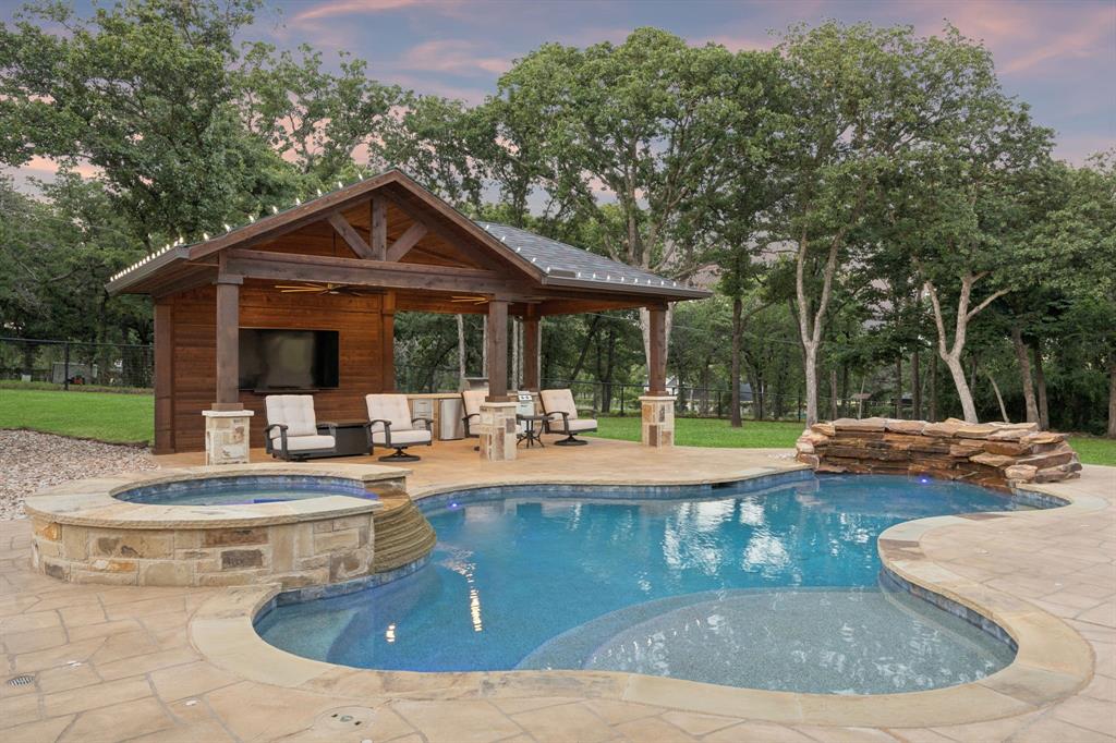 Modern farmhouse elegance on a meticulously maintained one-acre wooded site. Extensively renovated with over $600K in luxury improvements, this property boasts unmatched outdoor living and is designed for a homestead-inspired lifestyle. Incredible curb appeal begins with a welcoming wraparound porch, while upon entry, black steel-framed French doors seamlessly connect indoor and outdoor living. Designer-inspired kitchen boast beauty & function with expansive granite countertops, custom shaker cabinetry adorned with onyx pulls, dual farmhouse sinks positioned across multiple prep areas, and a premium KitchenAid appliance package complete with dedicated spaces for an ice maker and beverage refrigerator. The primary retreat features a renovated spa-inspired bath with freestanding soaking tub, frameless glass shower, and floor-to-ceiling marble-inspired tile surrounding the wet areas. From the primary suite to garage, no detail was overlooked, with custom Elfa organizational systems thoughtfully incorporated into all 5 bedroom closets, pantry & garage. Upstairs offers 4 generously sized secondary bedrooms, a flex space ideal for media or office, and beautifully updated baths with oversized frameless glass showers and designer finishes. Backyard is truly spectacular, anchored by a stunning custom-designed pool & spa featuring a raised spillover spa, cascading natural stone waterfall, and sun shelf lounging areas. Thoughtfully designed for both relaxation and entertaining, a custom vaulted cedar pavilion with built-in outdoor kitchen creates the ultimate setting for year-round gatherings. Completing the estate is a 30x20 shop with carport, dedicated gated garden & custom-built chicken coop with free-range enclosure. Full list of extensive updates available, however worth noting: New Roof, Siding, Windows, HVAC, Insulation, & Water Heater. Enjoy an exceptionally low tax rate of approximately 1.86% with no HOA and Zoned to New Scott Gibson Middle School opening August 2026.