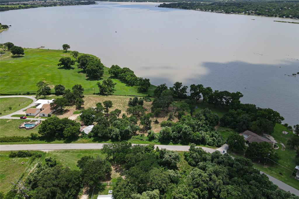 Rare opportunity to own 5.5 acres on the highly desirable shores of Lake Granbury, offering approximately 200 feet of lake frontage, a private dock, and breathtaking views of the water and surrounding landscape. Combining acreage, waterfront living, and exceptional outdoor amenities, this property presents a unique opportunity that is increasingly difficult to find.

The spacious residence features two primary suites providing a flexible floor plan designed for comfort and convenience. The updated kitchen is equipped with granite countertops, stainless steel appliances, double ovens, abundant cabinetry, and generous workspace, making it ideal for everyday living and entertaining. Step outside to enjoy your own private retreat complete with an in-ground swimming pool, hot tub, mature shade trees, and expansive outdoor space. The beautiful acreage showcases old-growth trees and offers room for recreation, gardening, hobbies, or future improvements while maintaining privacy and scenic surroundings.

Additional features include a two-car garage, two-car carport, and ample space for guests, recreational vehicles, or equipment. Whether you're seeking a full-time residence, lakefront getaway, or investment opportunity, this property offers the rare combination of acreage, waterfront access, and modern amenities.

Conveniently located just minutes from the Historic Granbury Square, you'll enjoy easy access to dining, entertainment, boutique shopping, wineries, live music, community events, and all that Granbury has to offer. Experience the best of Texas lake living with space to spread out, stunning waterfront views, and endless possibilities.