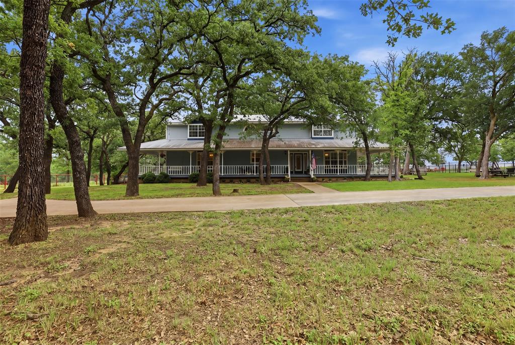 Beautiful custom 2-story farmhouse nestled on 6.44 private AG exempt acres with mature trees, fenced and cross-fenced pasture, and endless country charm. This 4-bedroom, 3.5-bath home features warm wood floors, and carpet in the living room and bedrooms, granite countertops, a spacious family room, and a walk-in pantry. The thoughtfully designed floorplan includes a secondary primary suite upstairs along with a small office and walk-in closets. Enjoy the large Primary suite downstairs with ensuite bathroom that includes a separate shower and jetted tub. 
Relax by one of the two wood burning fireplaces or Enjoy peaceful mornings and relaxing evenings on the expansive wrap-around porch overlooking the pool or scenic seasonal pond on the property. Outside, the acreage is ready for animals and hobbies alike with a loafing shed, barn with electric, a chicken coop and open pasture space. Tucked away for privacy while offering functional living both inside and out, this property combines farmhouse comfort with the perfect setup for country living.
Conveniently located just 12 minutes from Weatherford, 20 minutes from Granbury, and only 30 minutes from Fort Worth, this property offers the ideal balance of peaceful rural living with quick access to shopping, dining, and city amenities. Professional photos coming soon!
***AGENT IS OWNER***
