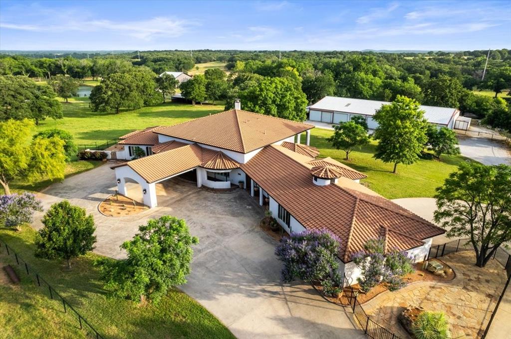 Welcome to your private equestrian haven, nestled in the scenic rolling hills of horse country USA, Aubrey, Texas. Spanning 23 pristine acres, this extraordinary ranch blends luxury living with first-class horse facilities, offering the ideal retreat for equine enthusiasts and those seeking space, style & serenity. At the heart of the property is a custom Spanish style estate home, exuding character & craftsmanship. With graceful stucco exteriors, terracotta style rooflines & arched architectural details, the residence offers an inviting blend of rustic charm & upscale elegance. Step inside to spacious, light-filled interiors designed for both comfort and entertaining, with high-end finishes & panoramic views of the surrounding pastures.  The house features a wonderfully appointed kitchen that looks onto the enormous living room with soaring high ceilings, double primary (one could convert to 2 private bedrooms making this a 4 bedroom home) bedrooms with dual closets in one, plus another oversized bedroom, large office, formal dining, safe room, oversized laundry area with private entrance from the exterior & 1,260sf 3 vehicle garage. Equestrian amenities include a turn key barn currently with 9 oversized stalls that can be converted to accomodate more if needed, tack and feed rooms, on-site office with vet area & restroom, plus private living quarters making this a fully operational and self-sufficient horse property. Expansive paddocks, fenced pastures, and ample space for riding complete the perfect setup. The Elk Fork Trinity River equestrian trail is just 1.5 miles away & the Lake Ray Roberts State Park equestrian trail is 10 miles.  Whether you're a professional trainer, breeder or recreational rider, this ranch delivers both the function you need and the lifestyle you deserve—all just a short drive from Dallas-Fort Worth & mere minutes to Denton.