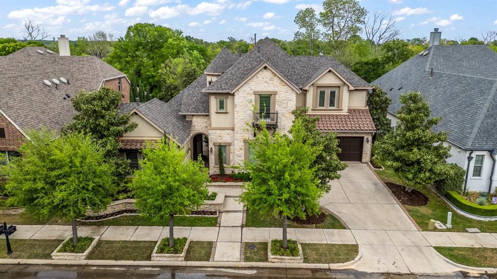 Experience refined luxury in this impeccably designed residence where timeless architecture meets elevated modern living. Curated landscaping, stone detailing, and a private courtyard with a water feature set the tone for what lies within. Inside, rich hardwoods, soaring ceilings with exposed beams, and designer finishes create an atmosphere of understated elegance. The expansive living area centers around a custom stone fireplace and flows seamlessly through a fully retractable sliding glass wall to a resort-style outdoor living space complete with covered patio, fireplace, built-in grill, and serene lake views. The gourmet kitchen is a true showpiece, featuring a 48” KitchenAid gas cooktop, double convection ovens with integrated microwave, quartzite countertops, an oversized island, custom cabinetry to the ceiling, a butler’s pantry, and an oversized walk-in pantry. A striking glass-enclosed, climate-controlled wine cellar offers storage for up to 850 bottles—perfect for the discerning collector. The primary suite is a private retreat with a spa-inspired bath, dual vanities, soaking tub, and custom walk-in closet with expansive built in shoe racks. Thoughtfully designed secondary spaces include a separate living space with its own HVAC, ensuite bath, microwave, and refrigerator—ideal for guests, multigenerational living, or private quarters. Split bedrooms offer privacy upstairs, sharing a Jack & Jill bath. The upstairs living room features 7.1 surround system, full bath, and storage under window bench. Additional highlights include a designer laundry room with dog wash station, Alexa-integrated smart faucet, all LED lighting, and a newly installed Class 4 impact-resistant roof. Outdoors, enjoy extensive hardscaping, a stone fountain feature, and wrought iron fencing in backyard overlooking the 106 acre open space with lakeview, a 3-car garage with wall pads, room for extra fridge, and breaker box with space for extra switches. Rare find in Viridian!