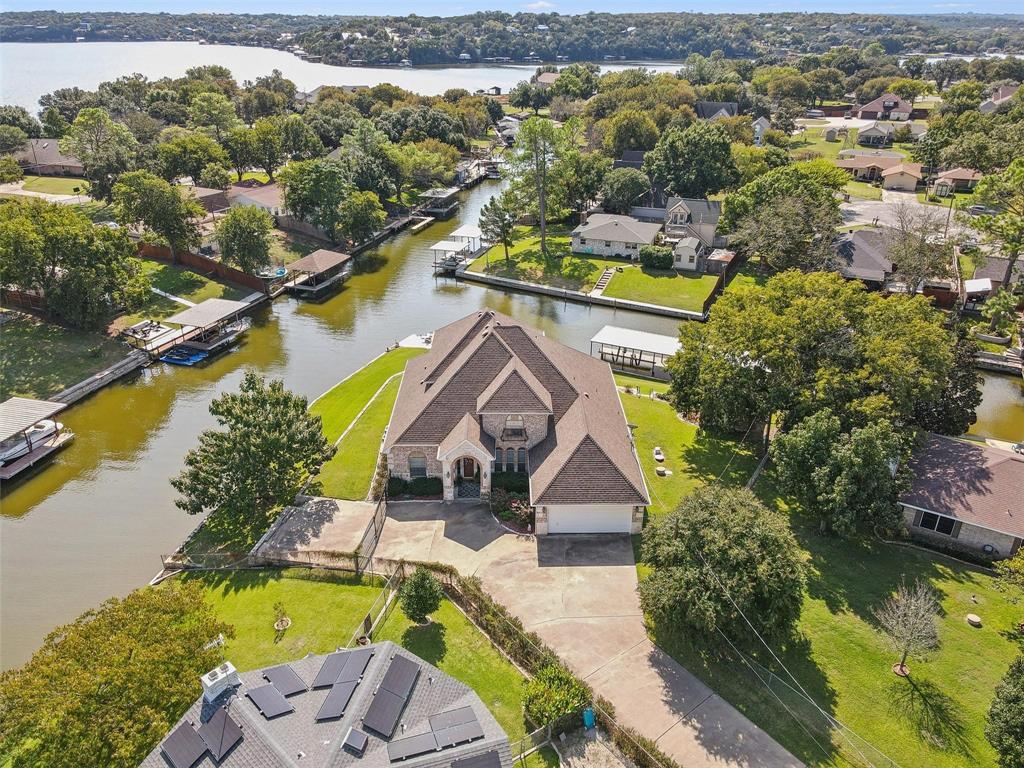 Welcome to this exceptional waterfront retreat located on a quiet cul-de-sac within the gated community of Indian Harbor. Situated on a spacious corner lot of nearly half an acre, this beautifully maintained home offers approximately 230 feet of canal frontage and direct access to the lake lifestyle you've been dreaming of. Recent updates include a new dock and retaining wall, roofing updates on the home and workshop, luxury vinyl plank flooring, and a new water heater. Inside, you'll find four generously sized bedrooms, two and a half bathrooms, open concept living space, dining room and a downstairs den. The primary suite opens to a covered patio overlooking the water, while the upstairs balcony captures expansive canal and lake views. A detached workshop with electricity provides additional flexibility for hobbies, storage, or workspace needs. Whether you're searching for a full-time residence or a weekend lake escape, this property delivers comfort, functionality, and outstanding waterfront amenities.