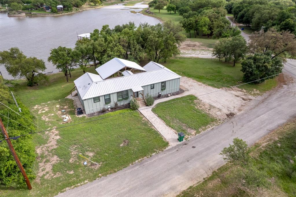 Welcome to your perfect lakeside getaway! This inviting 3-bedroom, 2-bath home sits right on the shores of Lake Brownwood and has been a proven short-term rental for years, offering both a peaceful personal retreat and strong income potential. Designed for effortless lake living, the home features a bright open floor plan perfect for entertaining or simply enjoying the view.

Large sliding glass doors invite you onto the expansive 60-foot deck, the true focal point of this home. With its vaulted wood ceiling, generous seating areas, and beautiful lake views, this deck is a perfect for relaxing, or family time. Grill out, unwind in the hot tub, or watch the sunset over the water with friends and family—this outdoor space is made for making memories.

Inside, the thoughtful split floor plan provides privacy and comfort for you and your guests. The spacious primary suite includes an ensuite bath and easy access to the laundry area, while two additional bedrooms and a full guest bath are conveniently located on the opposite side. Energy-efficient windows, durable metal roof and siding, and low-maintenance finishes make ownership simple and stress-free.

Outside, the gentle slope to the water leads you to a peaceful shoreline perfect for swimming, kayaking, or fishing just steps from your back door.

Located on a quiet road with tons of by mature trees in the backyard, you or your guests will feel right at home. Whether you’re looking to expand your investment portfolio, start a turn-key STR, or find your forever weekend escape, this property delivers the best of both worlds: income potential and tranquil lakeside living, all wrapped into one exceptional package.

This home can be purchased as-is for turnkey operation of the STR already in place. 

Come take a look today and make this piece of Texas YOUR next piece of Texas.
