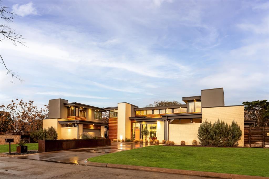 Located in the heart of Dallas, 9360 Lakemont Drive stands as the final masterpiece of renowned modern architect Tom Greico. Spanning 4,981 square feet, this residence masterfully blends industrial chic with functional luxury—from the visible texture of polished concrete floors to the invisible comfort of a seven-zone Russound audio  system and comprehensive Culligan whole-house water filtration.
The home's centerpiece is a sprawling chef’s kitchen, designed for connection. It features a unique serving window to the backyard and flows effortlessly into an open dining area and family room anchored by soaring, two-story ceilings. On beautiful Texas days, retractable sliding glass doors disappear to reveal a private, resort-style oasis. This outdoor sanctuary boasts an ozone purification pool, a sunken fire pit, and an outdoor kitchen with a built-in grill, all framed by multiple green spaces and a custom- built playhouse that architecturally mirrors the main
residence. The primary suite serves as a true sanctuary, offering serene outdoor views, a spa-inspired bath with a soaking
tub and separate shower, and an expansive walk-in closet featuring an oversized center island. Every detail of this home is elevated by modern convenience, including remote-controlled shades and high-end utility systems. Perfectly positioned near top-tier private schools and
walkable local favorites, this property represents a rare opportunity to own a significant piece of Dallas architectural history.