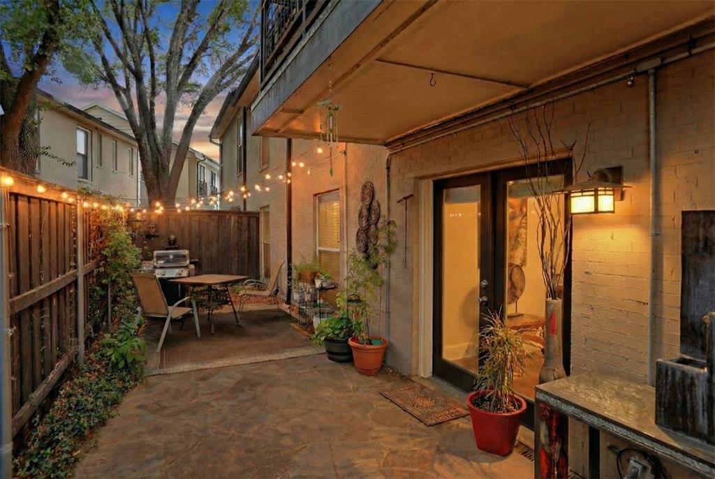 Two private outdoor spaces, a full-size patio for dining and grilling, and pool access just outside your door — this first-floor home at Paradiso doesn't live like a condo.

What sets this unit apart is the outdoor space. A private, fenced front courtyard gives you a separate entry feel with room for seating and plants. Out back, a full-size patio fits a dining table, grill, and lounge chairs — all behind privacy fencing. For a condo, this is rare.

Inside, the living and dining areas flow together across hardwood floors with crown molding overhead and natural light from multiple exposures. The kitchen features granite counters, white cabinetry, and a breakfast bar that opens to the main living space without closing anything off.

Three bedrooms give you real flexibility. The primary suite has its own dressing area, generous vanity, and walk-in tile shower. A second bedroom works equally well as a guest room or home office, and a third adds good closet space. The second full bath — with a jetted soaking tub — serves the rest of the unit.

Paradiso is a gated community minutes from NorthPark Center, Central Market, and the full run of restaurants and shops along Lovers Lane and Greenville Ave. Two assigned covered parking spots included.