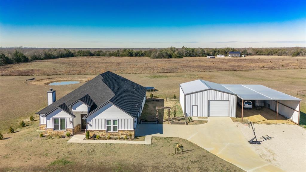 This is a rare opportunity to own a well-designed home with excellent shop space on 5 beautiful acres—functional, inviting, and ready to fit your lifestyle. The attractive home is complemented by wide-open views, a long concrete drive, and impressive outbuildings that make this property stand out.

Inside, the home features 4 bedrooms and 2 spacious living areas, providing flexibility for everyday living, entertaining, or a home office or playroom setup. The beautiful kitchen is the heart of the home, opening seamlessly to the main living area and offering ample workspace, storage, and a welcoming layout for gatherings. A separate laundry room adds convenience and keeps daily routines organized.

The primary bedroom is truly oversized, offering plenty of room for a sitting area or private retreat - Wait until you see the size of the closet! The en-suite bathroom is equally impressive, designed to feel like a spa with generous space and thoughtful finishes.

Outside is where this property really shines. The 30x40 shop is ideal for hobbies, storage, or a home-based business, while the additional 30x50 covered area is perfectly suited for an RV, tractor, boat, or additional equipment. With open acreage surrounding the home, there’s room to roam, garden, raise animals, or simply enjoy the peace and privacy of country living.  1% Lender credit if you use our preferred Lender.  Ask for details.