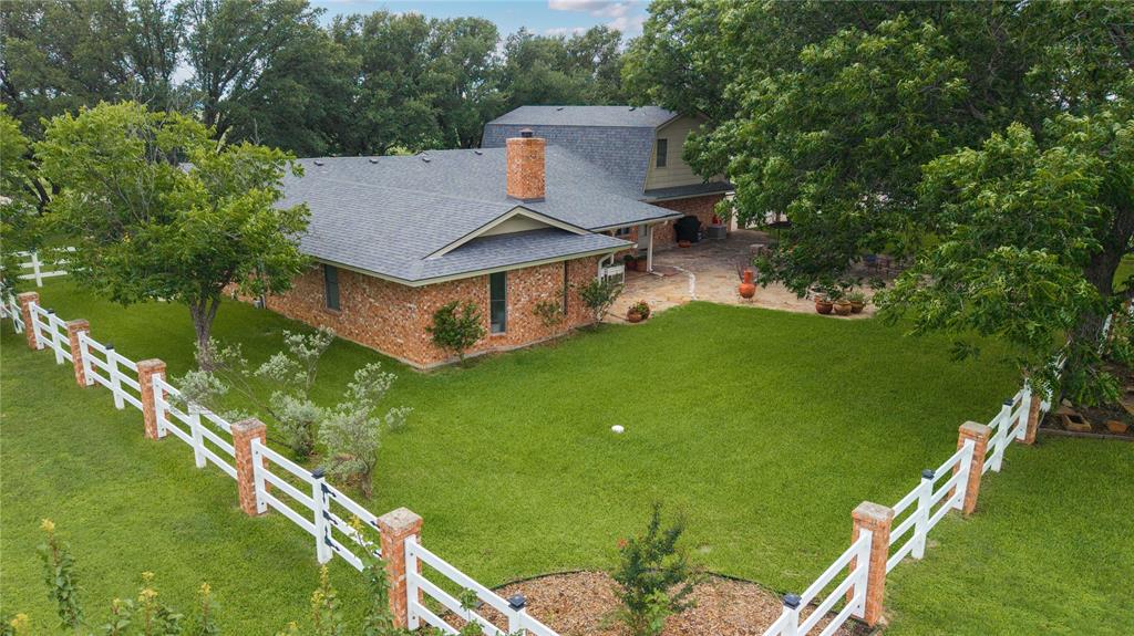 The best of both worlds-peaceful country living on 3 acres just minutes from town! This spacious 4-bedroom, 3 bath home offers room to spread out both inside and outside. Step into a welcoming living room featuring cathedral ceilings and a cozy wood-burning fireplace, perfect for gathering with family and friends. The formal dining room provides an elegant space foe hosting, while the large walk-through pantry adds convenience and abundant storage to the kitchen area. Recent updates include fresh interior paint, added insulation in the attic, all new windows and a new front door, giving the home a bright, refreshed feel and improved energy efficiency. Outside you'll love the covered patio for shaded relaxation, plus a large open patio complete with a firepit-ideal for entertaining or enjoying quiet Texas evenings under the stars. The property also features a versatile workshop or barn, perfect for hobbies, storage, livestock, or equipment. With acreage modern updates, and close-to-town convenience, this property truly offers the space and lifestyle you've been looking for.