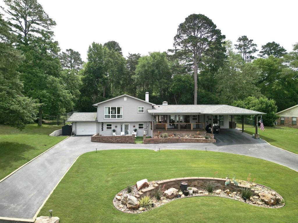 This home will take your breath away! From the high-end finishes to the stunning lake views, this is the one you've been waiting for! The spacious primary suite is up a few steps to allow sweeping views of the lake from the picture window. The bedroom also features a beautiful ensuite bath and roomy walk-in closet. The main floor boasts an open kitchen and living room with all the latest in practicality and cohesive design, making entertaining a breeze. The kitchen area gives another view of the lake with a relaxing deck area just outside the front door to take in the evening sunsets. In addition to the primary bedroom, there is a second bedroom with adjoining full bath and a hallway bath for guests. A downstairs bonus room features a fireplace, a kitchenette-bar area, a full bath, and a walk-in closet; perfect for an in-law or a third bedroom or game room. This home offers something for everyone and the options are endless. The front yard includes a circle drive leading to the double carport and the single garage and offers ample parking for all your guests. The backyard is a private outdoor living space you'll enjoy with your family and friends for years to come. Don't miss seeing this one!