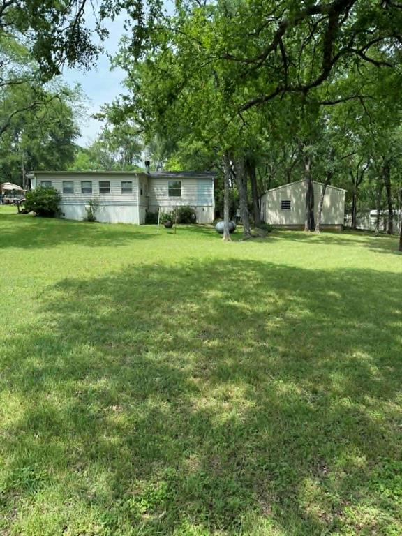 Beautiful property ideal for entertaining family and friends, whether as a weekend retreat or full time residence.  Double pie-shaped lot with road frontage on two sides. This inviting home features an open floor plan with a fireplace that can be wood burning and includes propane gas starter logs currently not connected.  Propane tank in front yard will remain with the property.  Anderson windows throughout were updated less than approximately  five years ago.  The primary bedroom includes a relaxing jetted walk-in tub.  Enjoy the enclosed front porch filled with natural light from numerous windows, plus a covered back porch with ramps for easy access.  The storage shed located behind the home includes electricity and attic space.  A spacious two and one half metal detached car garage offers a concrete  slab floor, two overhead doors and garage door openers.  Home could use a few updated to make it your own and will need leveling.  All offers will be considered.  Property is owned by agent of record.  Buyer and buyers agent to verify all information provided, which is deemed reliable but not gauranteed.