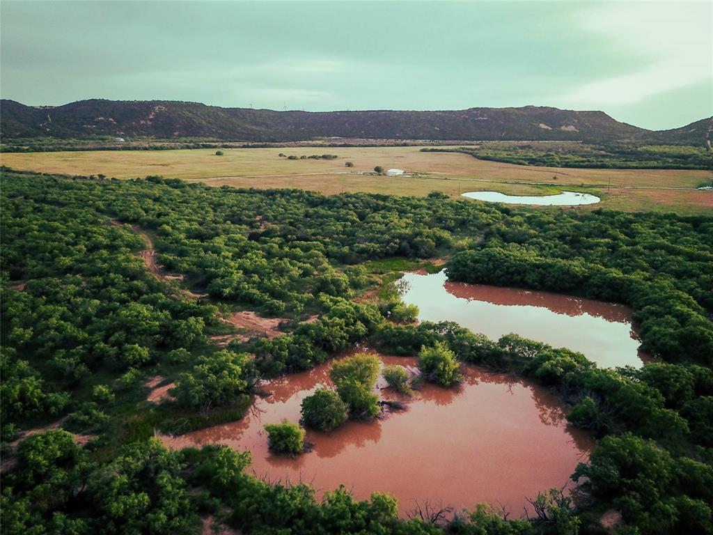 Rare investment opportunity to own land and minerals in West Texas for only $3,600 per acre! Seller is also willing to sell the East 250 acres and West 350 acres and house at the same price point! The 600 acre Bronderosa Ranch is a proven wildlife sanctuary tucked away into the hills 11 miles southwest of Abilene. The ranch features a 1,080 SF hunter's cabin, barn, two water wells, perimeter fencing and cross fencing, several good sized ponds scattered throughout, and 6 blinds and 9 feeders that will convey. The property has a rural water meter with Blair Water Supply and a buried line that extends from near the main gate into the south portion the ranch. The ample road frontage and rural utilities (water and fiber) in the area also provide exceptional ranchette development potential. The owner will convey all minerals owned, reportedly 50% of total according to the seller. Buyer to verify exact mineral interest and location of utilities. Property is currently leased for grazing and hay production.