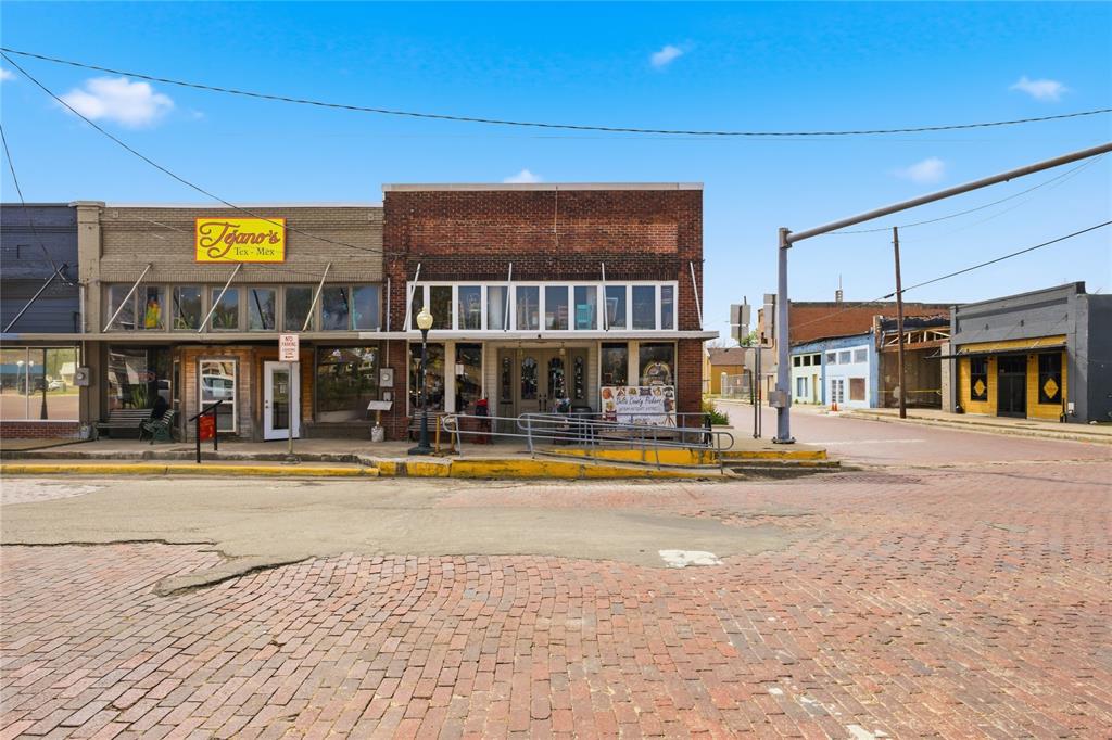 This beautiful historic building sits on a prime corner of the Cooper, Texas square, offering incredible visibility and high traffic for any business opportunity. Full of charm and character, the property features an antique store on the main level, complete with its own restroom and office space.
Behind the retail space, you’ll find two separate housing units. Each unit features its own living and kitchen downstairs and their own stairs leading to two bedrooms and one bath each upstairs. The residential portion has been completely remodeled and includes brand-new HVAC systems. Separate access to the living quarters is conveniently located off the side street. With endless potential, this property is ideal for retail, a sandwich shop, ice cream parlor, steakhouse, airbnb for living areas or a variety of other business ventures. Whether you’re looking to invest, live, or create something new, this one-of-a-kind property offers the perfect blend of location, functionality, and opportunity.