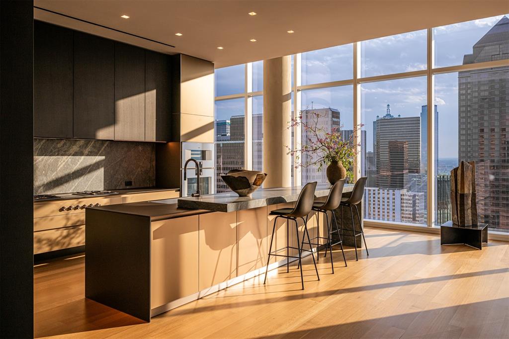 The Gallery Penthouse at HALL Art Residences in the Dallas Arts District is a full-floor custom home on the 26th floor. Direct elevator access into this 4 bedroom, 4 bath, 2 powder bath home with 7,688 sq ft offers floor-to-ceiling windows, 12-foot pocket doors and hand-troweled plaster columns throughout. The Living Room showcases 14-ft ceilings, a monumental fireplace and wine cellar. The gourmet kitchen is designed with bulthaup cabinetry, Gaggeneau appliances and an oversized customizable butler pantry. Enjoy unobstructed panoramic views of the Dallas skyline in the dining room and private terrace. The primary bedroom suite is a serene retreat complete with its own private terrace. The spa-inspired en-suite bath offers two spacious walkin closets, soaking tub, large shower, heated floors, and a smart mirror. Other distinctive features are a private library with a fireplace, 2 utility rooms and raised flooring system. This home was designed by Abeyta Tibbs Architecture.