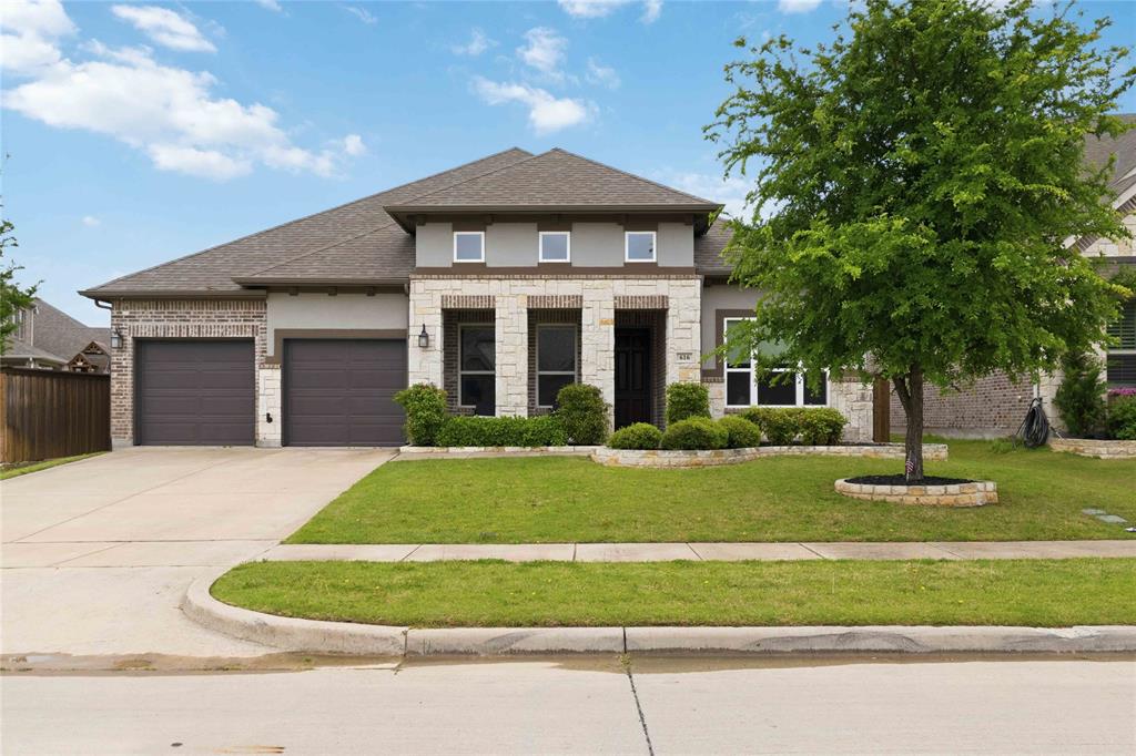 Experience refined living in this stunning custom home in Trinity Falls! Gracefully appointed on a premium lot w-an expansive, oversized backyard designed for both grand entertaining & everyday luxury. A timeless blend of brick, stone & stucco creates an unforgettable first impression, complemented by a welcoming front porch that sets the tone for what lies within. Inside, a richly appointed private study with a wood-paneled accent wall and serene front yard views offers a sophisticated work-from-home retreat. The formal dining room is elegantly scaled, ready to host memorable gatherings and elevated dinner parties. At the heart of the home, the grand living room impresses with a dramatic floor-to-ceiling stone fireplace, abundant natural light, and picturesque views of the sprawling backyard, seamlessly flowing into the designer kitchen. The kitchen is a true showpiece, featuring an oversized island with storage, striking triple pendant lighting, a gas cooktop with vent hood, double ovens, SS apps, custom cabinetry & a crisp white subway tile backsplash, perfectly blending style & function. Adjacent, a secondary living area provides a versatile space ideal for a game room or kids space, while a dedicated media room tucked behind solid doors invites immersive movie nights at home. The private primary suite is a tranquil retreat, enhanced by tray ceilings and a beautifully updated en-suite bath with dual sinks, framed mirrors, a separate shower + a renovated, boutique-style walk-in closet designed for luxury. Step outside to your extended covered patio, complete with a natural gas hookup, creating the perfect setting for outdoor kitchens and year-round entertaining. The expansive backyard offers endless possibilities, whether envisioning a resort-style pool, sports court, or lush garden oasis. This remarkable home masterfully blends intentional design, a striking & highly functional floor plan + designer finishes, all set on an massive lot that truly sets it apart.