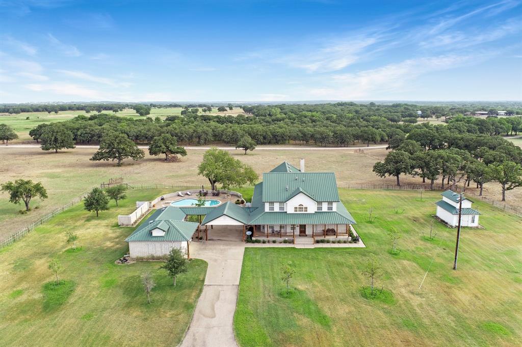 This impressive and meticulously manicured paradise is located directly across from the Infamous TR9 Ranch and on a quiet cul-de-sac. Enjoy your favorite beverage in the sparkling built-in pool. This spectacular property is perfect for entertaining family and friends with the expansive floor plan, wet bar, wood burning rock fireplace, and a gas 2 sided fireplace in the primary suite. The spacious breezeway connects to the workshop garage. Never run out of H20 with 2 wells and a 3,000 gal storage tank. An equine therapy business is run out of the 2 barns located on the property. The main barn features 28 14x14 stalls, an in ground Aqua-tred, hot and cold salt water Nautilus spa and an Equivibe Therapy plate as well as an office with a full bathroom. The second barn, completed in 2023, features 10 14x14 stalls with runs. Included is a 4 horse sweep hotwalker, and an outdoor roping arena with great sandy loam soil. This property is located less than 1 hour from the Will Rogers Coliseum.
**Property is back on market due to buyers contingency falling out.**