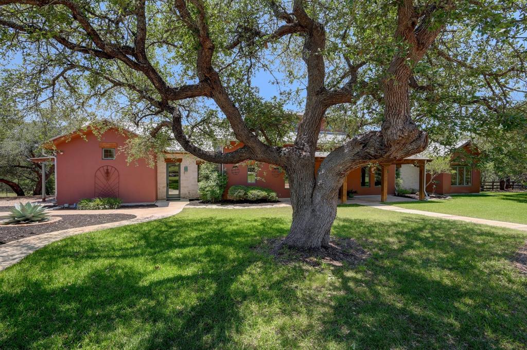Exceptional 41.6-acre Hill Country estate in the highly desirable Fitzhugh Corridor, offering panoramic views, exceptional privacy, AG exemption, and endless possibilities just minutes from downtown Dripping Springs and within acclaimed Dripping Springs ISD. Behind a private gated entrance and long scenic driveway, this unrestricted property blends luxury, natural beauty, and functional ranch living into one extraordinary offering. Surrounded by mature oak trees, native landscaping, abundant wildlife, rolling grassy pastures, and a beautiful creek feeding into Barton Creek, the property is ideal as a private family compound, equestrian estate, wellness retreat, winery, or potential commercial opportunity. The custom home features multiple office spaces, wraparound porches, slate floors, exposed ceiling beams, a built-in library bookcase, and walls of windows framing stunning Hill Country views. The gourmet kitchen is designed for entertaining with custom cabinetry, expansive prep space, and three sinks. Built with quality and efficiency in mind, the home includes ICF construction, geothermal HVAC with three zones, central vacuum system, Pella windows with built-in blinds, sprinkler system, and whole-house rainwater collection with approximately 30,000gallons of storage. A private well services outdoor water use and can also supply the home if needed. Equestrian improvements include horse pens, complete perimeter and cross fencing, pole barn, run-in shed, detached garage-shop with workshop, kennels with built-in dog washing station, and grassy areas ideal for horses. Wildlife exemption currently in place through Plateau Wildlife Management helps maintain favorable property taxes while preserving the natural beauty of the land. A rare opportunity to own an extraordinary Hill Country property offering unmatched privacy, breathtaking scenery, refined craftsmanship, and exceptional versatility in one of the area’s most sought-after locations.