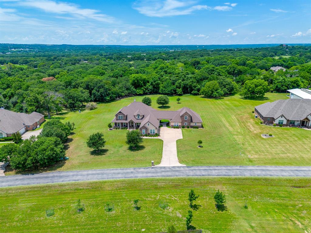 Welcome to this exceptional multi-generational estate on 2.58 acres in the highly desirable gated community of Boling Ranch Estates. Featuring two separate homes, this rare property offers privacy, flexibility & luxury living surrounded by mature trees, abundant wildlife & breathtaking natural views.
The main residence offers 3,671 sq ft with 4 bedrooms, 4.5 baths. Designed for both everyday living & entertaining, the open-concept floor plan features rich wood floors, formal dining room, floor-to-ceiling custom built-ins & a stunning rock wood-burning fireplace. The spacious kitchen opens to the living area & includes granite countertops, stainless steel appliances, custom wood cabinetry, a Butler’s coffee bar & breakfast area. The primary suite is conveniently located downstairs & features a spa-like ensuite bath with separate vanities, soaking tub, oversized walk-in shower & large walk-in closet. An additional guest bed is downstairs, while two bedrooms & a game room are located upstairs. Every bedroom has access to its own dedicated bathroom. Additional highlights include a 3-car garage & an oversized covered patio perfect for outdoor living.
The separate 1,948 sq ft full size guest house offers its own private entrance & is ideal for extended family or guests. Features include a large living room, dedicated office, spacious kitchen with granite countertops & stainless steel appliances, walk-in pantry, utility room, half bath & an oversized primary suite with sitting area & ensuite bath. Upstairs are two additional bedrooms & a full bath, plus a private patio overlooking the peaceful surroundings.
Recent updates include a new roof, newer HVAC, new water heater, gutters & beautiful landscaping. Located adjacent to the community pool, this move-in ready property offers a unique opportunity to enjoy luxury country living with modern conveniences. Watch deer & wildlife from your porch while enjoying the tranquility of this stunning, private, tree-lined community.
