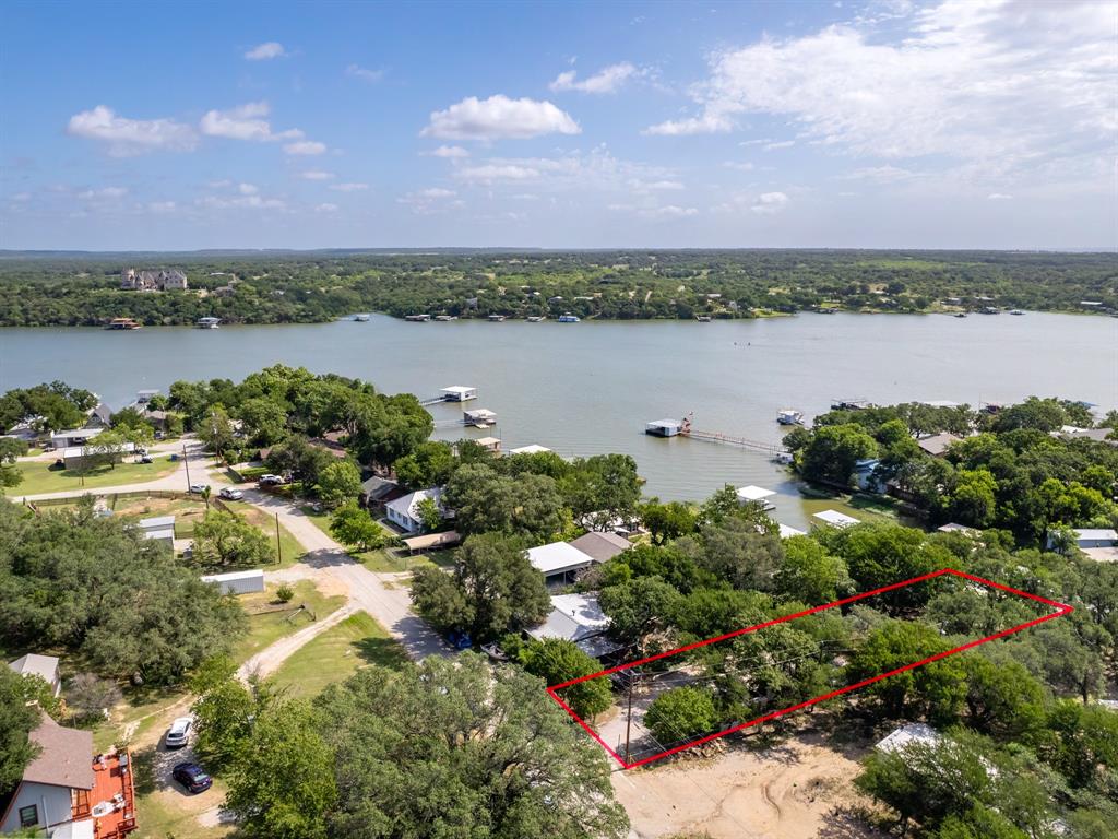 Live full-time or enjoy as the perfect lake getaway! This 3-bed, 2-bath, 1,752 sq ft home on a 0.4-acre lot offers space, comfort, and great water access. 

The spacious living room features a wood-burning fireplace and lake views. Step up to the dining area, updated kitchen with an island, and easy access to a full bath. A Murphy bed by the side door adds extra sleeping space without taking up floor area. 

Both front bedrooms function as primary suites, offering flexibility and comfort. The third bedroom is a fun bunk room with a wall-mounted heating and cooling unit. 

The patio, featuring a grill, table, and chairs beneath mature trees, is ideal for outdoor gatherings. From there, you can easily access the sandbox and playground, with a path leading to the stunning waterfront. 

Enjoy a strong concrete retaining wall at the water’s edge, steps leading into the lake, an impressive dock with a boat lift, jet ski platform, and a cozy boat cove. A lakeside shed keeps toys and gear handy. 

Two carports offer covered parking with room for a boat or RV. Sheds provide extra storage or workshop potential. Fully furnished and move-in ready, this one has it all! 

Groceries and essentials are just minutes away. It’s only 7 miles to The Hideout Golf Resort and 15 miles to vibrant downtown Brownwood. Schedule a private showing today and come experience lakefront living at its best!