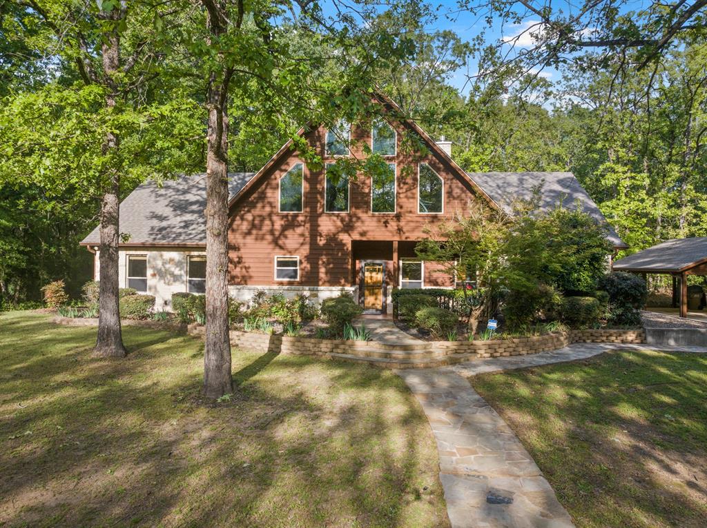 Luxury and privacy come together in this stunning custom cedar and stone home, ideally situated on 4.9 acres just minutes from both Lake Cypress Springs and Lake Bob Sandlin. With Cypress Springs boat launch only one mile away and Bob Sandlin just three miles down the road, this property offers rare proximity to two of East Texas’ most sought-after lakes—perfect for boating, entertaining, and weekend getaways. Inside, the home makes an unforgettable first impression with soaring 26-foot aspen ceilings, massive spruce beams, and a dramatic floor-to-ceiling rock fireplace anchoring the main living space. The open-concept design flows seamlessly into a beautifully appointed kitchen with granite countertops, ideal for both everyday living and hosting. The primary suite is a true retreat, featuring dual vanities, a spa-inspired soaking tub, an oversized travertine tile shower with bench, and a spacious walk-in closet with thoughtful built-ins. Upstairs, the loft creates the perfect entertaining space, complete with a custom black walnut wet bar, refrigerator, and TV hookup—ready for game days or relaxed evenings with guests. Step outside and enjoy the space and versatility this property offers, including a 40x60 shop with approximately 500 square feet of living quarters—ideal for guests, a private office, or additional living space. Set on nearly 5 acres with a prime location near both lakes, this property delivers the perfect blend of luxury, functionality, and lifestyle—whether you’re looking for a full-time residence or the ultimate weekend escape. Call today to schedule your private showing!