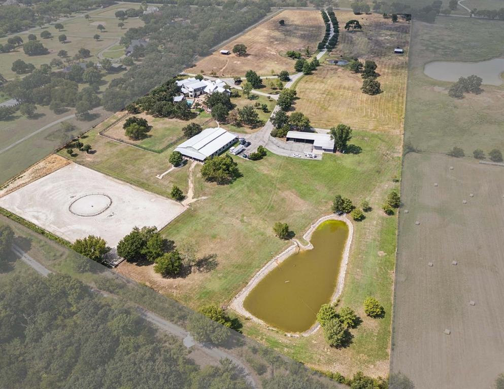 Breathtaking Estate with Equestrian Features in the Heart of DFW!
Welcome to 480 E Jeter Road, a 26-acre Bartonville estate that blends the rugged beauty of Country living with the comfort and convenience of DFW. With 12,833 sq. ft. of living space, including 9,683 sq. ft. in the main residence plus 3,150 sq. ft. in guest apartments and offices, this property offers unmatched flexibility for multigenerational living. The main residence showcases stone architecture, a standing-seam metal roof, hardwood floors, and refined finishes.
The main home features two chef’s kitchens with Miele, Sub-Zero, Wolf, and Bosch appliances, a Control4 smart system, and a primary first-floor suite with two custom bathrooms and direct pool and patio access. Upstairs, nearly 2,000 sq. ft. functions as an independent residence with gym, bedrooms, 2 full baths and full kitchen.  The private exterior entrance, or the use of the interior dedicated elevator, the ADA-accessible suite is perfect for both young and old. 
Outdoor amenities include a resort-style pool with fountains and fire features, a removable child-safety fence, and a 48 kW Generac generator with dual 1,000-gallon propane tanks powering the home for up to a week. The barn adds offices, restrooms, laundry, and a 1-bedroom apartment. Equestrian facilities include a 700 sq. ft. run-in shed, 13 stables, automatic watering stations, and an irrigated outdoor arena. The property also includes a FEMA-rated safe room, dual Brown Safe Co. safes, soft-close cabinetry, a 1.3-acre dog park with shower.
With 45,000 sq. ft. of paved parking, zoning that allows 5-acre lots, and proximity to Liberty Christian, DFW Airport, Plano, and Dallas, this estate is both a retreat and investment.
Private, luxurious, and versatile, this Bartonville estate is a rare opportunity to own a one of a kind estate in the Metroplex, where lifestyle, luxury, and location come together.