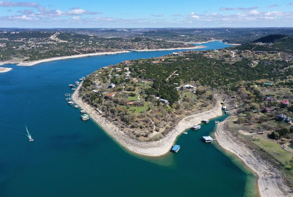 Extraordinary Lake Travis waterfront estate in the Sandy Shores community of Volente. Over 1,100 feet of deep-water frontage along both the main body and a quiet cove, breathtaking views, gentle topography, and a level build site—ideal for a dream estate, family compound, or potential development (Buyer to verify). Both walkable and drivable access to the shoreline. Minimal floodplain and unobstructed views, this property is primed for long-term enjoyment and investment. Lake Travis, known for its crystal-clear waters and expansive shoreline, is one of the largest and cleanest lakes in Central Texas. At low levels, it offers four times the navigable water of Lake Austin—and at full pool, that number rises to ten—yet with notably lighter boat traffic, making it perfect for recreation and relaxation. A 3-bedroom, 2-bathroom home with a fireplace is currently situated on the property and used as a short-term rental. Water is drawn from the lake to service the residence. Whether for full-time living, income-producing use, or guest accommodations during future development, the home adds immediate functionality to the property. Located just 10 minutes from 620-2222 and the shopping, dining, and entertainment options of Cedar Park—and only 35 minutes to downtown Austin—this is lakefront living at its finest. Zoned to highly acclaimed schools, including Vandegrift High School. All acreage options: 11 Acres with Home 9.41 Acres without Home 1.48 Acres with Home