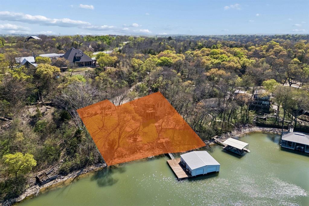 Discover the ultimate opportunity to own a rare piece of waterfront paradise on Moss Lake. Perfectly positioned on a stunning double waterfront lot with approximately 149 feet of pristine shoreline, this exceptional property offers endless possibilities to build your dream lake retreat, luxury getaway, or investment property in one of North Texas’ most desirable lakefront settings. From the moment you arrive, the gated entrance and peaceful surroundings create a sense of privacy and escape. Towering trees, breathtaking water views, and expansive shoreline provide the perfect backdrop for unforgettable sunsets and relaxed lake living. Whether you envision a custom waterfront estate, weekend retreat, or income-producing vacation property, this lot offers the ideal canvas to bring your vision to life. Designed for those who love the outdoors and entertaining, the property already features incredible lakefront amenities including multiple outdoor gathering spaces, a firepit area, and a private dock and boathouse for effortless days on the water. The oversized additional waterfront lot creates even more value and flexibility, offering potential for future expansion, additional structures, or a second build site. With panoramic lake views, direct water access, and unmatched development potential, this is a truly rare opportunity to secure a premier waterfront property on Moss Lake. Whether you are searching for a personal escape, an investment opportunity, or the perfect place to create lasting memories, this one-of-a-kind lakefront property delivers the lifestyle you’ve been dreaming of. Please see MLS#21217238 for interior photos of the house.