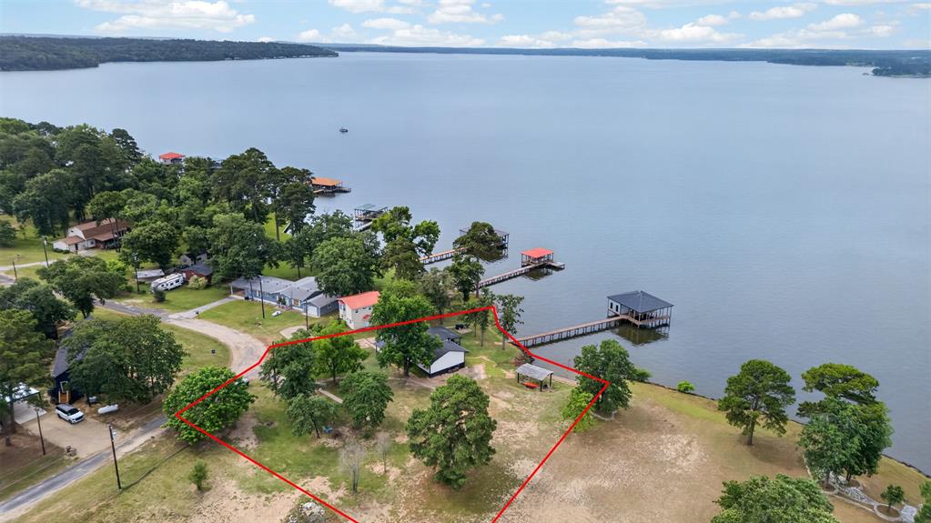 Perched on a breathtaking Lake Palestine waterfront, this property offers 156 feet of open shoreline, unforgettable sunsets, and the peaceful lake lifestyle buyers rarely find. From the moment you arrive to the water, the view steals the show — sparkling big water, experience seeing soaring eagles, and a constant cooling breeze that makes every day feel like a vacation, even in the middle of a Texas summer. Enjoy your own private beach area, a two-year-old boathouse, and plenty of room for entertaining family and friends on the water. With additional room to build, this property also offers incredible future potential — expand the existing home, add a guest house, a shop, create the ultimate lake compound, or simply enjoy the extra space and privacy. This beautifully updated waterfront retreat combines comfort, charm, and endless possibilities. The 1,680-square-foot primary home has been thoughtfully improved throughout.   You get a new roof, HVAC system, granite countertops, updated appliances, and more.  You will fall in love with the new lakeside deck designed for relaxing evenings and front-row sunset views.  Outside, the property becomes truly extraordinary. Whether it’s morning coffee by the lake, afternoons on the boat, or evenings watching the sky turn shades of orange and gold, every moment here feels special.  Properties with this combination of big-water views, updated improvements, beach access, boathouse, and buildable space are incredibly rare on Lake Palestine. This is more than a home — it’s a waterfront experience.