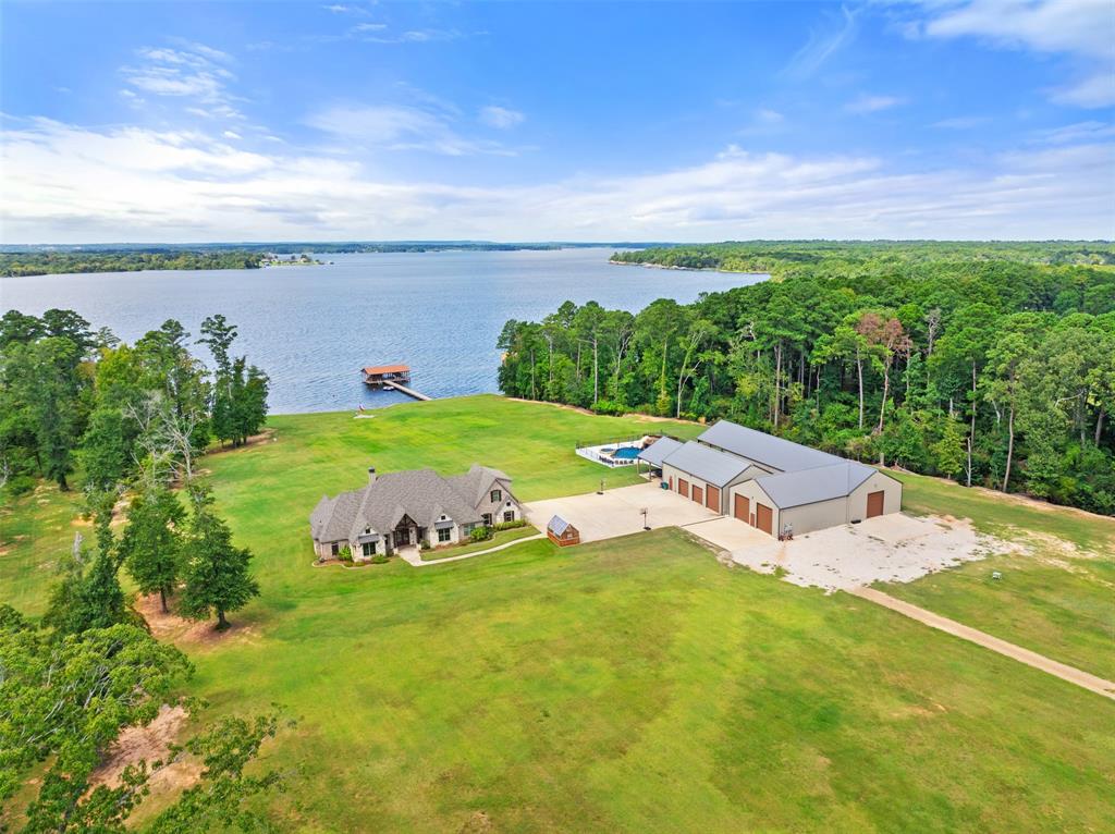 It is my pleasure to present this unparalleled, sprawling Lake Palestine legacy estate. Incredibly rare, this 72 acre waterfront property has over 1250 feet of Lake frontage, all within the Bullard ISD boundaries. For the discerning few who demand life uncompromised, this is a once-in-a-lifetime opportunity to enjoy the convergence of absolute privacy and prime convenience, on Lake Palestine. The 3715 sf custom residence was built in 2019 and includes 4 bedrooms, 3 bathrooms, an office, formal dining and game room. Coffered and vaulted ceilings, abundance of natural light, professional-grade appliances and bespoke craftsmanship are just a few of the highlights found throughout. The chlorine pool and hot tub were added in 2024. The pool includes a grotto, diving board and slide along with a chiller for those hot days. The boathouse was built in 2023 with 100%Trex decking. Included are 2 boat slips, with 5K lb and 10K lb lift motors. There is a secured storage room, automatic mosquito and bird repellent system, slide and ladder and LED lighting. Even the utility side of the property is first-class. Over10,000 sf of insulated and HVAC equipped shops cater to your collection of Ferrari's or John Deere's. Or choose pickleball or carpentry or rock climbing; there is climate controlled space for all of it. Remote driven shades and BigAss Fans cool the covered patios as you BBQ and enjoy the sunset. This is a generational asset, based on the enduring value of vast, private, waterfront acreage in a sought-after location. The sheer volume of high-quality improvements, all recently completed, ensures that the new owner can simply turn the key and begin a life of unrivaled luxury and complete seclusion. Not to be repeated or replicated, your memories start here. Qualified buyers are invited to schedule a private viewing to fully appreciate the scope and exclusivity of this extraordinary Lake Palestine estate