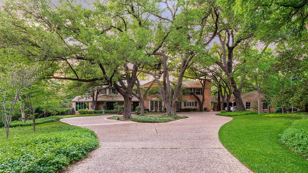 Offered for the first time in decades, this distinguished estate presents one of Bluffview’s most treasured settings. With its timeless, understated allure, the 1940 Howard Meyer–designed residence rests on more than two acres of exceptional topography framed by majestic trees and mature landscaping. Beginning with its picturesque private drive, the property reflects a rare sense of scale, privacy, and architectural integrity.  Spanning almost 9,400 sq ft with generous room proportions, high ceilings, and floor-to-ceiling picture windows, you’ll be swept back to a time of gracious entertaining, treasured family gatherings, and a home filled with love, laughter, and adventure. The first level is anchored by a welcoming foyer and elegant formals showcasing sweeping views of the spectacular grounds. A light-filled sunroom with an arched ceiling and brick flooring offers a tranquil retreat. Overlooking the lawn, the charming central library appointed with basketweave-patterned hardwoods, a full bath, and one of four fireplaces leads to an expansive Saltillo-tiled great room.  A whimsically hand-painted kitchen and breakfast room capture the warmth and charm of this enchanting home, while intricate moldings, double staircases, silver closets, generous storage, and an elevator accessible from three sides add to its thoughtful design. Upstairs, the primary suite offers a spacious sitting room and two full baths, each with generous closets and dressing areas. Five additional bedrooms (or four + a game room) and three full baths complete the second level.  A collection of detached spaces enhances the property’s versatility, including a two-room guesthouse, a cabana or fitness studio, and separate pool baths. The breathtaking grounds of 5007 Seneca are nearly indescribable. Enveloped in lush, manicured landscaping, brick pathways meander through multiple patios and a impressive brick-bordered parterre garden while expansive green lawns encircle this extraordinary setting.