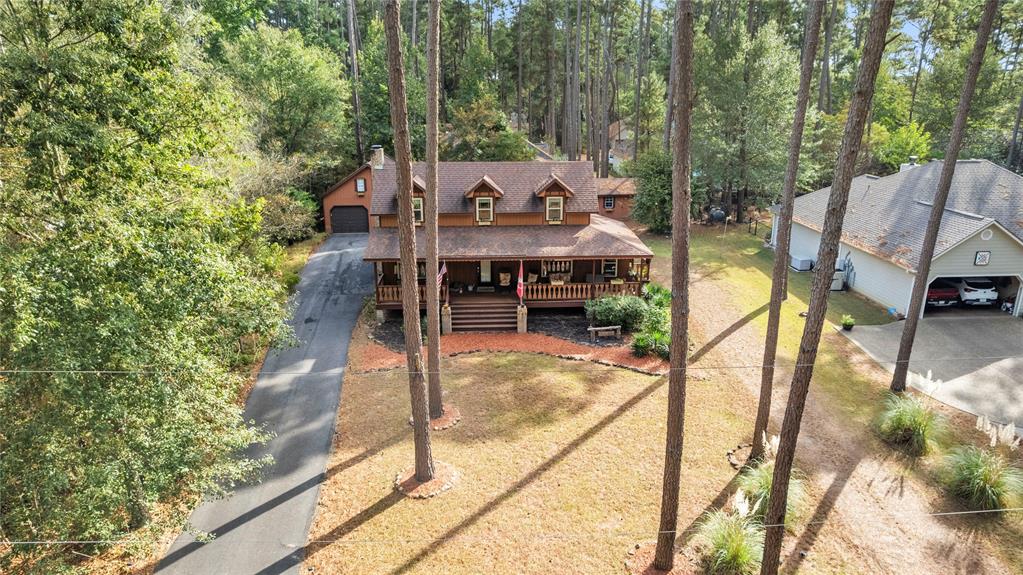 East Texas living located in the gated community of Holly Lake Ranch. This 3-bedroom, 2-bath home comes with a bonus private, oversized garage and upstairs apartment and is set on a wooded cul-de-sac, offering privacy and a true retreat style setting. The main living area is defined exposed timber beams, an open flow, and a wood-burning fireplace, creating a warm and inviting place to relax, with the feature of a bonus room off the kitchen. This open layout flows seamlessly into the kitchen and dining areas, designed for both everyday living and entertaining. The primary suite is located on the main level for convenience, while the upstairs provides flexible space for guests, office, or additional living. The laundry space also leads into the first floor living space. The second floor boasts two bedrooms and a full bathroom. The cedar exterior complements the natural landscape, blending indoor comfort with the surrounding wooded environment. A separate 2-car garage plus upstairs apartment adds versatility for guests, extended stays, or income potential. The backyard flows openly with a fire pit and wood shed large enough for a golf cart and workbench. All doors in this home are solid wood, new windows with economic double-glaze. RV parking and hookups with electrical are already there! Holly Lake Ranch amenities includes gated security, an 18-hole golf course, multiple private lakes for fishing and boating, swimming pool, fitness center, tennis and pickleball courts, scenic walking trails, clubhouse, on-site dining, and a full calendar of community events. A rare opportunity to own a private, amenity-rich retreat in one of East Texas’ most established resort-style communities.