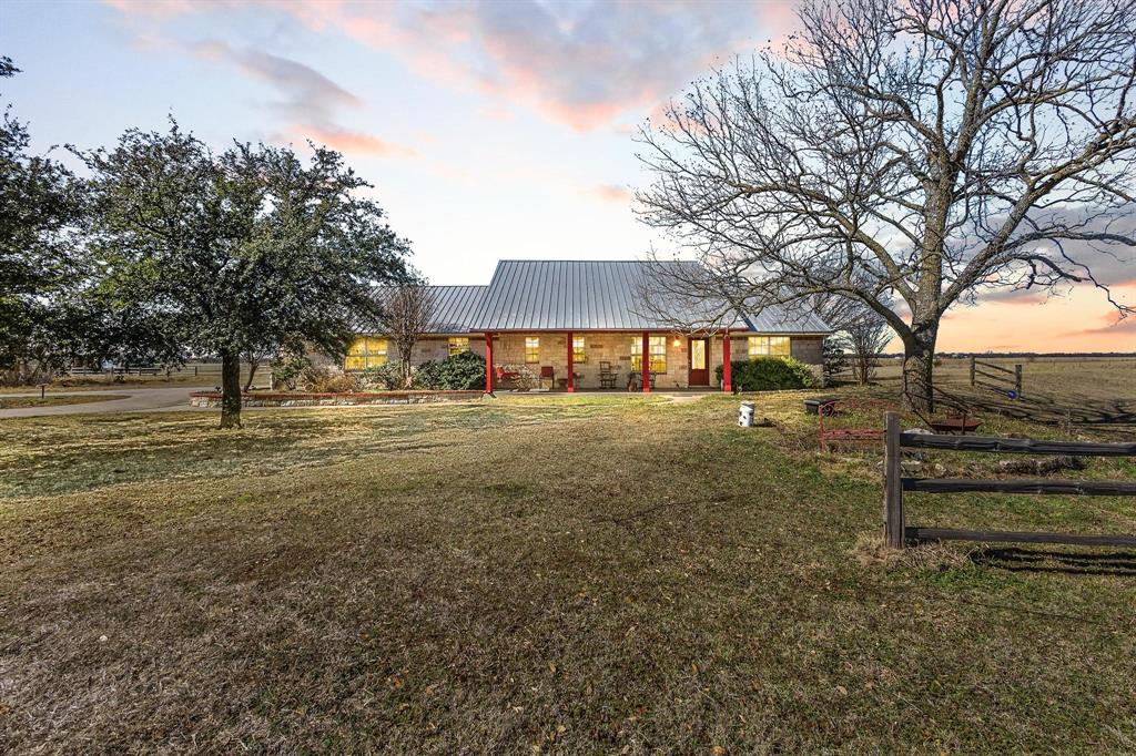 Welcome to 1233 FM 901 in rural North Texas: a custom built 1788sf 3 bed 2 bath ranch home sitting on 4.8 UNRESTRICTED acres with a 1200sf shop. Walking through this home, you can't help but appreciate its custom touches such as the custom cabinetry in the kitchen along with display shelves, accordion appliance hutch, two tier sink in addition to a prep sink in the island, pullout shelves in the pantry, and throughout crown moulding, trimmed windows, stone fireplace, wainscoting ceilings in the hall bath and one secondary bedroom, and a walk-in storage area in the garage. The primary suite offers a jetted tub, fireplace in the bathroom, standing shower, separate vanities, laundry shoot, large walk-in closet with built-ins, and doorway exit leading to the back porch. Exterior features include a metal roof, front and back porches that stretch across the home, stone and brick exterior, covered deck with a pergola and hot tub, a stone entrance that leads to the circle driveway, and pipe cross fence. The shop offers 1200sf of workshop, storage, or simply additional life space fully equipped with upgraded LED lighting, workbenches, a half bathroom, is wired for electric and plumbed, has its own septic system, with a RV hookup on the south side. This country property will be livestock ready with the easy addition of one cross fence. 25 minutes from Sherman, 45 minutes from McKinney and Frisco.