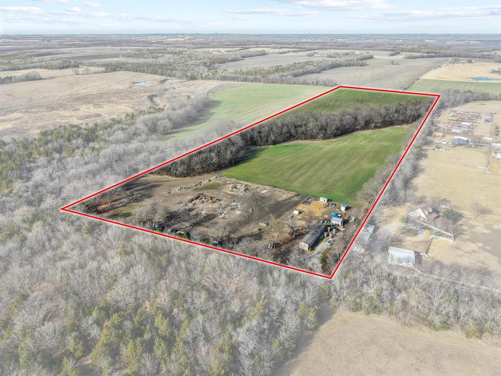 Escape to 23 pristine acres of North Texas countryside, where wide open skies meet incredible investment potential. This rare Sherman tract offers the perfect foundation for a custom estate or farm land, currently benefiting from a full Ag-exemption and productive winter wheat cultivation. Unlike many large parcels, this property is 100% situated outside of the floodplain, offering total peace of mind and unlimited options for your future home site, barns, or workshops. A, vehicle-crossable creek runs along the tree-lined perimeter, providing a serene natural backdrop and a sense of wooded privacy without sacrificing accessibility. The property currently features a functional 1,216 sqft single-wide manufactured home with 3 bedrooms and 2 bathrooms. A ideal solution for immediate living, a rental income stream, or a comfortable home base while you oversee the construction of your dream residence. Whether you’re looking to build high on a hill or nestle into the trees, this expansive acreage offers the rare combination of high and dry land, established agricultural value, and the quiet freedom of country living.