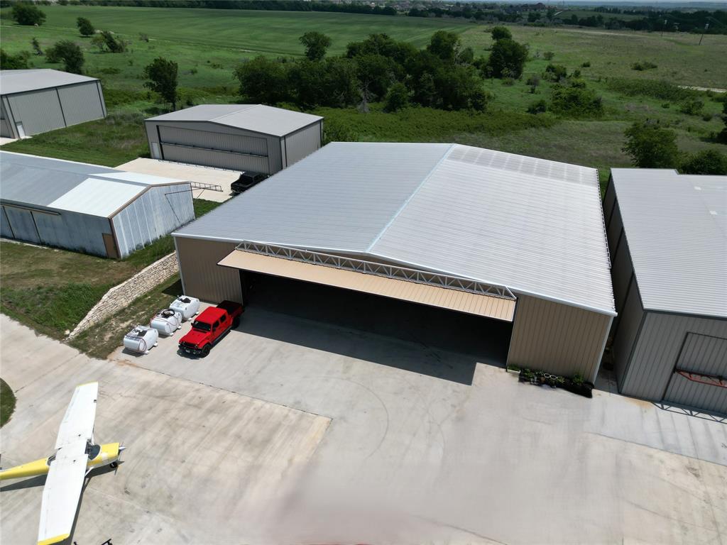 Rare opportunity to own a 10,000 sq ft airplane hangar at Bourland Field (FAA 50F), ideally positioned on a 0.51-acre lot with a large concrete pad. This well-equipped facility features a 65' x 17' Higher Power door, offering excellent access for a wide range of aircraft. Inside, you’ll find a 1,000 sq ft apartment, a 1,000 sq ft climate-controlled workshop, and 2 bathrooms, making it perfect for both aviation and extended use. The hangar is serviced by water and septic and includes a 5-ton HVAC system for year-round comfort. Bourland Field offers a 4,049' x 60' paved runway, and the location provides convenient access to the entire DFW Metroplex. Ideal for pilots, collectors, or anyone needing substantial aviation-ready space.