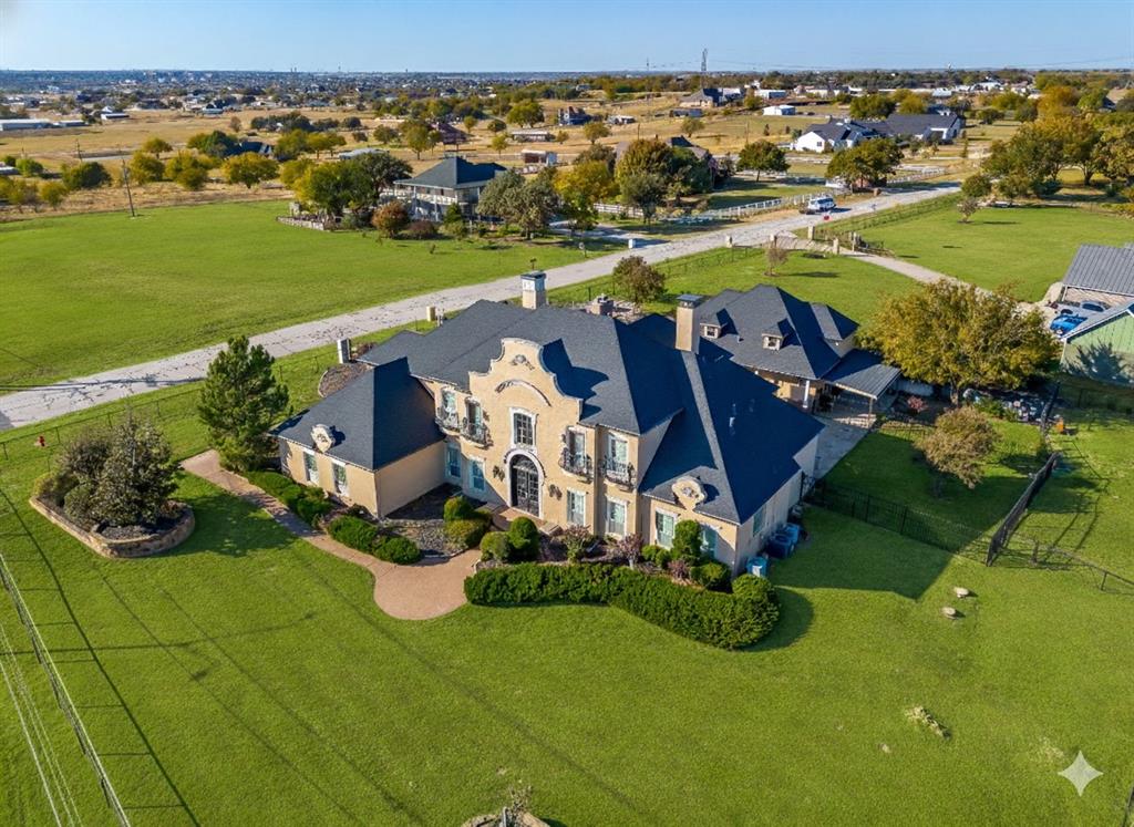 A Northwest Tarrant landmark, this home is perched high on a hill affording incredible views all the way to downtown Fort Worth. Including nearly 4.5 acres with pond, this luxurious 4,757-sq-ft custom home offers an exceptional blend of elegance and comfort, featuring a sparkling inground pool with spa, private guest quarters, and ample space for pets. Prime LOCATION, LOCATION, LOCATION, in the heart of Alliance with quick access to literally EVERYTHING. If you are looking for THE HOME that everyone knows, this home is for you!!! Guests are greeted with an impressive entryway, towering ceilings, and a grand staircase, ushering them into the spacious family room with its impressive wall of windows overlooking the private courtyard and pool, flooding the home with natural light. This Entertainer's dream offers 2 large living spaces, an upstairs game room & wet bar with plenty of room for a pool table, and a separate media room! The chef’s kitchen boasts a large island with 6-burner gas cooktop, granite countertops, top-of-the-line custom-matched appliances, farmhouse sink, double ovens, and an inviting breakfast bar. The recently remodeled home’s other notable features include rich hardwood and oversized tile flooring, popular neutral tones, generously sized bedrooms with abundant storage & extensive built-ins perfect for displaying artwork and more. The primary suite exudes warmth with its own fireplace and a spa-inspired bath featuring a soaking tub, separate shower, dual sinks, and a spacious walk-in closet. Need space for a Parent, Adult Children, or Home Business-Office? The 1,200 sqft private guest home features its own kitchen, living room, dining area, two bedrooms, and two bathrooms with laundry space. This property is set up perfectly to build your shop at the back corner with its own separate entry off of Harmon Road for all your toys, RV, or business equipment. There is also a Potential Future commercial opportunity as well!! Truly An Absolute Must SEE!