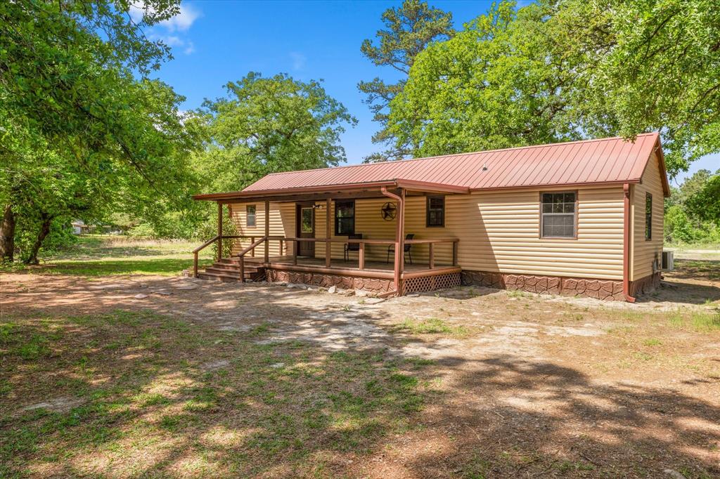 Set against the backdrop of East Texas countryside, this distinctive rustic retreat on approximately 6 acres presents a unique combination of charm, flexibility, and future potential. Featuring dual primary suites with private baths on opposite ends of the home, the layout is ideal for comfortable living or accommodating guests. Located just outside the Quitman city limits in a peaceful rural setting, the property also benefits from substantial highway frontage, offering excellent visibility and accessibility. The true highlight is the land itself—both open plus wooded, and filled with possibilities. Whether envisioned as a tiny home community, income-producing investment, business venture, private homestead, or future development opportunity, the options are virtually endless. With no known restrictions, this versatile property lends itself to residential, commercial, mixed-use, or recreational purposes. Whether you’re seeking a weekend escape, rental investment, business location, or long-term development potential, this is a rare opportunity to own acreage with both flexibility and visibility in a growing area. The home has been recently updated and refreshed with new paint and wood treatments.