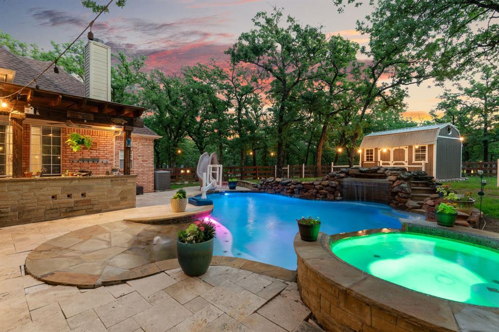 FREE 1-0 RATE BUYDOWN WITH PREFERRED LENDER ON RATES LOCKED BY JUNE 30! Tucked away on a quiet corner lot in the highly desirable Shadow Wood Estates, where there’s no HOA and room to truly live. This property delivers the kind of backyard experience buyers dream about.
From the moment you arrive, the welcoming entrance sets the tone, instantly making you feel at home. Inside, the layout is both functional and inviting, with a bright, open kitchen that seamlessly flows into the main living space. The kitchen is thoughtfully designed with double ovens, a gas cooktop, and decorative backsplash; perfect for everyday living and entertaining alike. In the living room, custom built-ins cleverly conceal the TV, allowing the fireplace to remain the true focal point, all framed by expansive windows overlooking the backyard oasis.
And that backyard… It’s the showstopper. Surrounded by mature trees for privacy, this outdoor retreat features a sparkling pool, fire pit, and multiple entertaining spaces, creating the perfect setting for everything from quiet evenings to unforgettable gatherings.
The primary suite is privately tucked away on its own wing, offering a peaceful escape complete with a cozy fireplace and a beautifully updated bath featuring a standalone soaking tub and oversized shower. A secondary bedroom with a full bath downstairs provides the ideal setup for guests or a private in-law suite.
Upstairs, you’ll find two additional bedrooms connected by a shared ensuite bath, along with a spacious game room that offers flexibility for play, work, or relaxation.
Car enthusiasts, hobbyists, or those dreaming of extra space will love the 3-car garage plus an impressive 35x22 two-story garage-shop, perfect for a workshop, storage, or easily convertible into an ADU or party barn.
All of this, zoned to highly acclaimed Argyle ISD, makes this home a rare opportunity to enjoy space, privacy, and lifestyle without compromise.