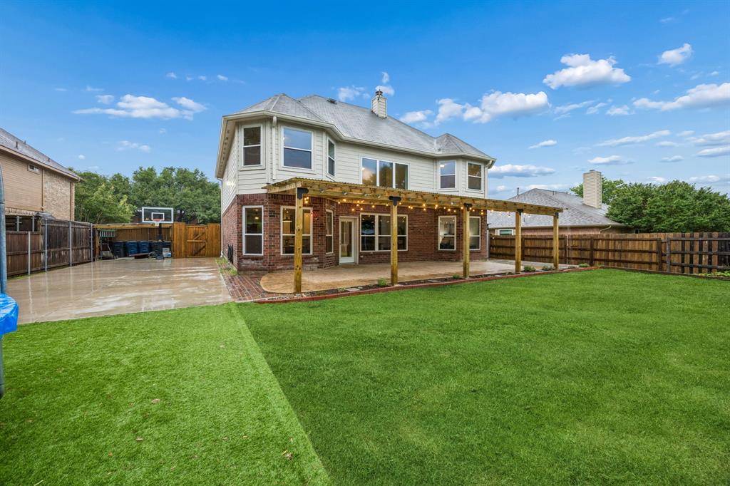 Vaulted ceilings, a fully reimagined designer kitchen, and a backyard built for unforgettable nights and weekends set the tone for this upgraded 4-bedroom, 3.5-bath home, just minutes from Hwy 75 and historic downtown McKinney. Step through the front door and into soaring living spaces filled with natural light and all-new paint, warm luxury vinyl plank flooring, and an open-concept layout that feels both expansive and inviting. The renovated kitchen steals the spotlight with rich navy blue cabinetry, gold hardware, quartz countertops, double ovens, a gas range with pot filler, and all appliances replaced in 2022. Originally designed as a formal dining room, the remodeled layout now creates an extended kitchen and entertaining area with additional cabinetry and counter space ideal for a coffee bar, serving station, prep area, or hosting spread during gatherings. The breakfast nook adds another layer of function and charm with built-in seating, hidden storage, and backyard views. The downstairs primary suite offers room to unwind, complete with oversized windows and a spacious ensuite bath with dual vanities and a dedicated makeup area. Blackout blinds in every bedroom help create restful retreats throughout the home. Upstairs, the library is a rare standout feature with walls of built-in shelving ready for books, collectibles, hobbies, or a quiet work-from-home setup. The backyard is where the home further sets itself apart. A massive 35’ x 17’ patio and covered pergola create an outdoor living space made for game days, late dinners, and slow evenings outside. Beyond the patio, the yard features a full sport court with an in-ground Goalrilla basketball goal, turfed trampoline area, and storage shed. Big upgrades, flexible spaces, exciting outdoor living, and a location that keeps you close to shopping, dining, and commuter routes, while still feeling tucked away, all make this one a home you can’t miss.