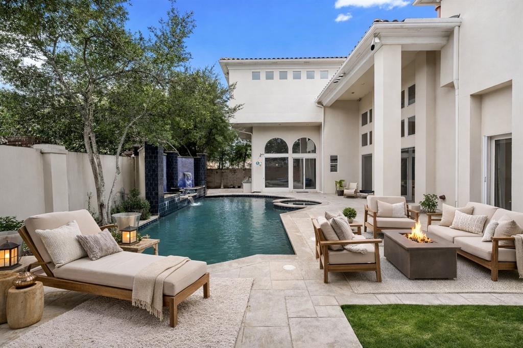 Set within the guard-gated enclave of Oakdale, this Simmie Cooper–designed contemporary estate delivers a rare blend of modern artistry and timeless craftsmanship, moments from Bent Tree Country Club and Plano ISD’s top-tier schools. 5608 Stone Cliff Court reintroduces itself with renewed presence an architectural statement designed for those who value privacy, design, and an elevated everyday lifestyle at the end of a quiet cul-de-sac. From the moment you enter, soaring ceilings, walls of glass, and curated sightlines create an effortless connection between indoors and out. Sunlight fills expansive living spaces designed to host everything from intimate gatherings to large-scale entertaining. At the heart of the home, the chef’s kitchen is a true showpiece featuring Sub-Zero refrigeration, Wolf gas cooktop, 4 Wolf ovens, and a commercial vent hood perfectly suited for culinary creativity and memorable evenings with friends and family. The main-level primary suite offers a private retreat of rare scale and serenity, complete with a fireside sitting area, dual custom closets, and a spa-inspired bath with steam shower. A second ensuite bedroom on the main floor provides flexibility for guests or multigenerational living. Upstairs, three oversized ensuite bedrooms each feel like a private sanctuary, complemented by a media room with wet bar, a generous home office, and a versatile flex space ideal for a gym, studio, or playroom. Step outside to your own resort-style escape: a covered lounge, built-in outdoor kitchen, and a pool with fountains and spa, all surrounded by lush landscaping designed for both celebration and quiet evenings under the stars. Slate roofing, newly updated tile flooring, are some of the home’s enduring quality and thoughtful design. For buyers seeking security, architectural distinction, and a lifestyle that balances sophistication with ease, this reimagined offering is an opportunity to experience one of North Dallas’ most exclusive addresses