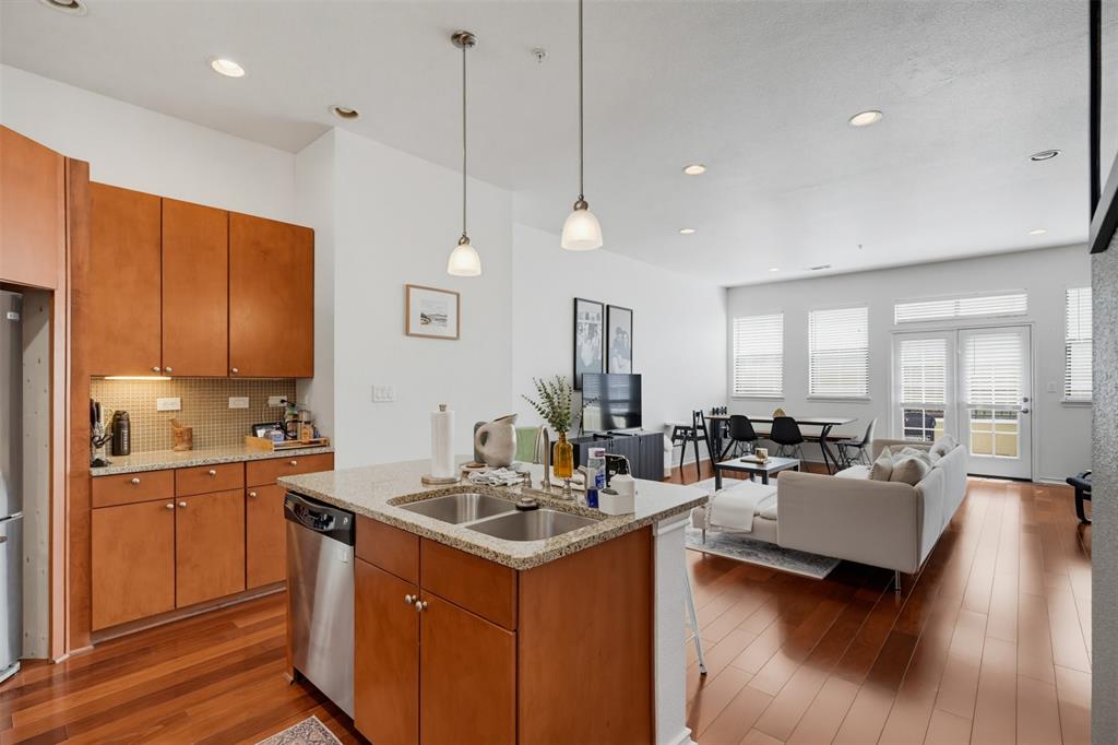 Tucked inside a secured gated community, this three-story townhome gives you privacy and quiet just steps from the heart of Arlington's entertainment district. Walk to Globe Life Field, AT&T Stadium, and Texas Live!. Inside, the open concept design features rich hardwood floors, granite countertops, stainless steel appliances, and a warm color palette throughout. The first level offers a private bedroom with a full bath, perfect for guests or a home office. The second level opens into a bright kitchen and living area with a convenient half bath for entertaining. The third level holds the primary suite with private bath, plus a third bedroom with its own full bathroom. Take the spiral staircase up to the rooftop terrace and you'll see why this home was made for hosting. The HOA covers lawn care and the sprinkler system, so there's no outside maintenance to worry about.