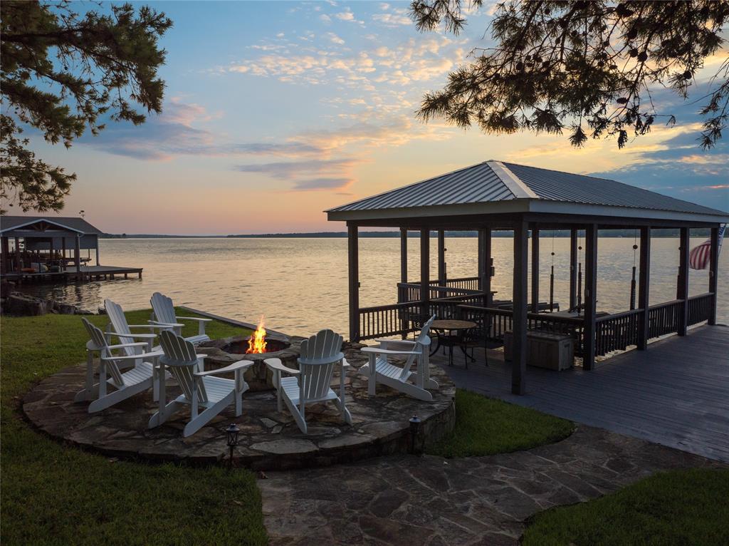 Discover a one-of-a-kind sanctuary on Lake Bob Sandlin at Thunderbird Point where luxury meets lakefront living. This exquisite property offers the perfect balance of comfort and elegance. The first floor welcomes you with a cozy living area showcasing stunning lake views, a see-through fireplace, and a dining space flooded with natural light. The primary suite is a true retreat with its private exit to the top deck porch and a lavish ensuite bath featuring a Jacuzzi tub, dual sinks, and a spacious shower. Downstairs, the fully renovated living area provides ample space for relaxation and entertainment, while the gourmet kitchen offers a front-row seat to breathtaking sunsets over the lake. The primary suite exudes sophistication with a modern ensuite bath, while the chic bunkroom is designed for both comfort and fun. Outside, the expansive back porches set the stage for memorable gatherings, leading to the 1,600 sqft boathouse with 180 ft of waterfront equipped with new lifts for all your watercraft needs. Unwind by the custom fire pit under the stars, surrounded by luxury touches like a new roof, freshly painted dock, and meticulously maintained grounds. Indulge in the ultimate lakefront lifestyle at this remarkable property. With proven VRBO income, this is multiple venture property waiting for you!