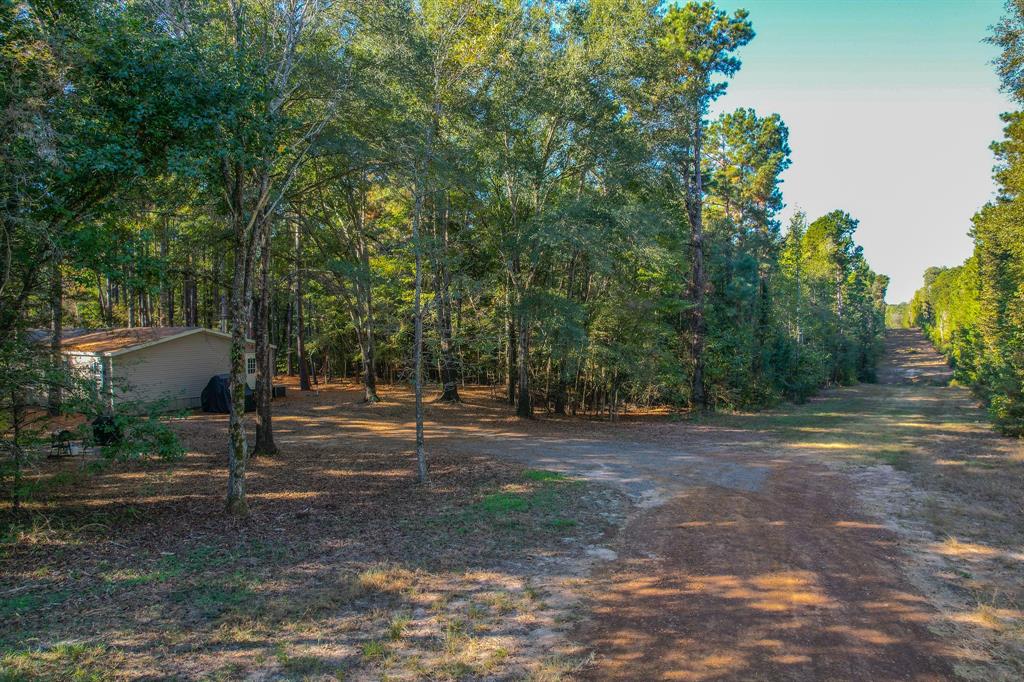 Escape to the peace and privacy of the country with this beautiful 15.5-acre wooded retreat offering an excellent mix of comfort, recreation, and natural beauty. The property is heavily wooded with a healthy combination of hardwood and pine timber, creating a secluded setting with excellent wildlife habitat and an abundance of whitetail deer and other native game. Whether you enjoy hunting, trail riding, hiking, or simply relaxing outdoors, this property offers the perfect setting to enjoy nature.  A clear water spring add to the property's charm and provide a scenic focal point tucked within the timber. The well-maintained 32’x76’ mobile home is situated among the trees and offers a spacious open floor plan with 4 bedrooms and 2 bathrooms. Inside, you’ll find quality finishes, generous living areas, and a large master suite complete with a walk-in closet and private bath. Whether you are looking for a full-time residence, hunting retreat, or weekend getaway, this property combines modern comfort with the beauty and seclusion of East Texas living. Approximately 38 additional acres available if desired. Call today to schedule your private showing!