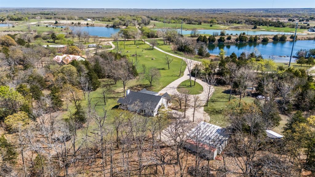 Discover a rare East Texas retreat offering 10.1 picturesque acres, plus private access to a 60-acre spring-fed lake, just minutes from Lake Tawakoni and under 55 minutes from East Dallas. This exceptional property blends peaceful seclusion with endless opportunities for recreation, relaxation, or income potential.

A welcoming entrance opens into a light-filled home featuring cathedral ceilings, expansive windows, and an open-concept design capturing breathtaking 180-degree views of nature. The living area is anchored by a striking stone fireplace, creating a warm and inviting space. The modern kitchen flows seamlessly into the main living area, ideal for everyday living and entertaining.

The home offers three bedrooms and three and a half baths, including a serene primary suite with a spa-like bath and double vanities. A secondary bedroom with exterior access and kitchenette provides flexibility for guests, multigenerational living, or rental use. A private office with French doors adds functionality for working from home.

Outdoor living shines with a full-length front porch with two swings and a side porch to enjoy the peaceful surroundings. The property includes two tiny-home shell containers with metal awnings, two storage containers, a 40x40 storage building, a large garage with workshop, and unfinished attic space for future expansion.

Partially wooded acreage with trails and a greenbelt backdrop ensures privacy and a true retreat feel. A cell booster provides reliable connectivity.

Truly one of a kind, offering acreage, lake access, and unmatched versatility.